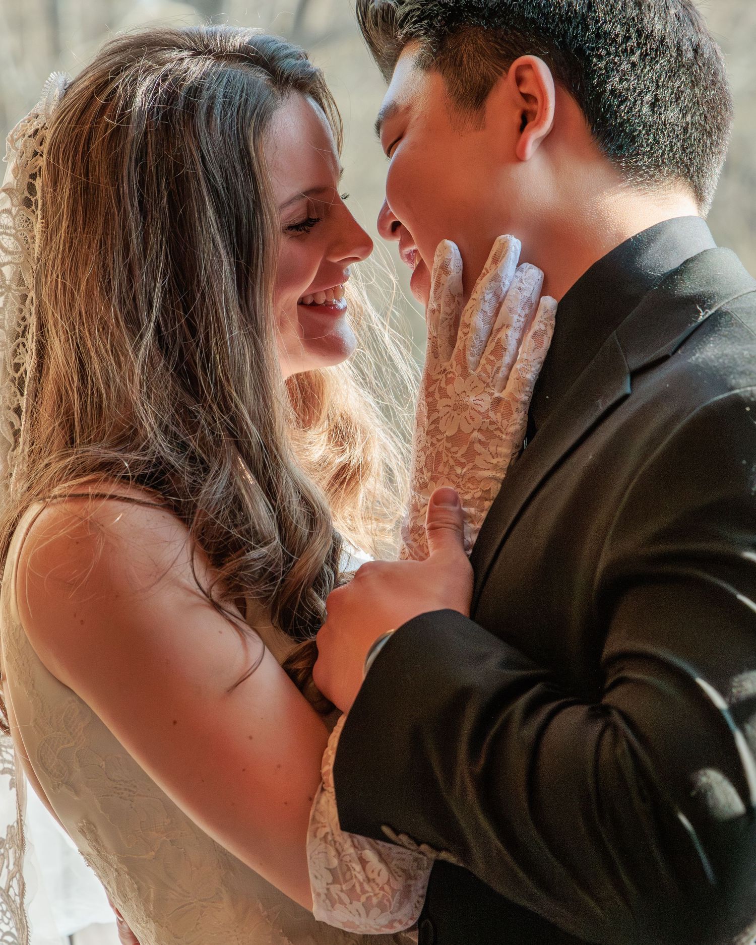 An intimate moment between a couple sharing a close embrace near a window.