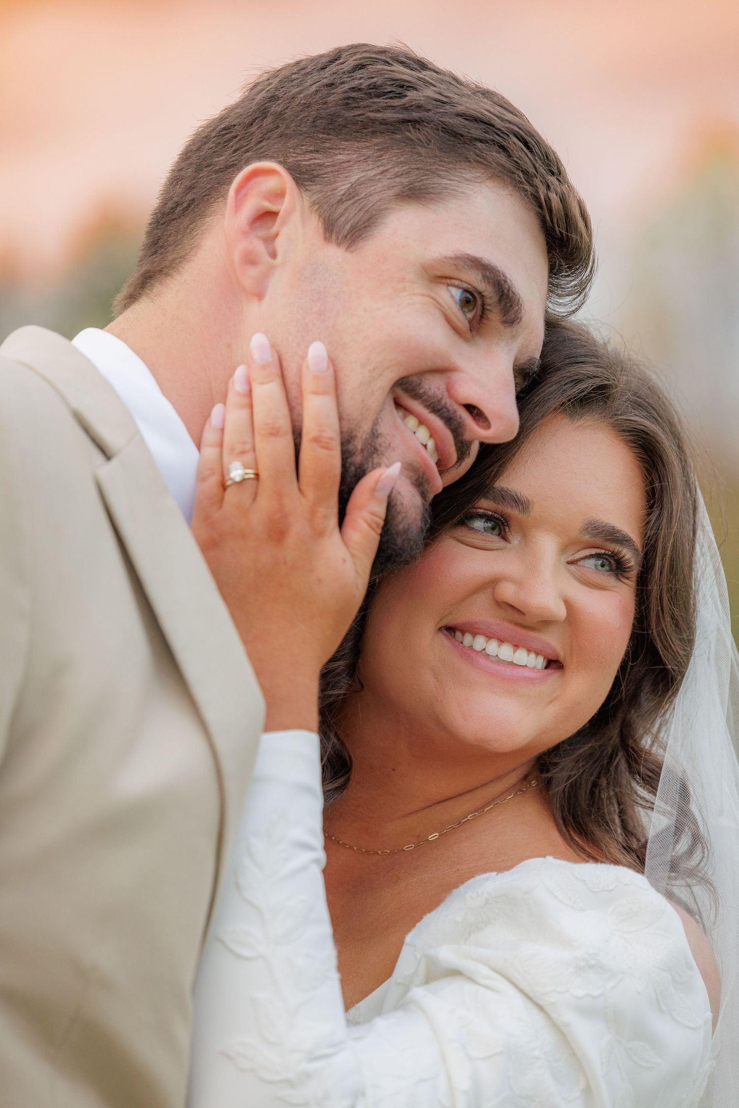 A close-up moment between newlyweds sharing a tender embrace during golden hour.