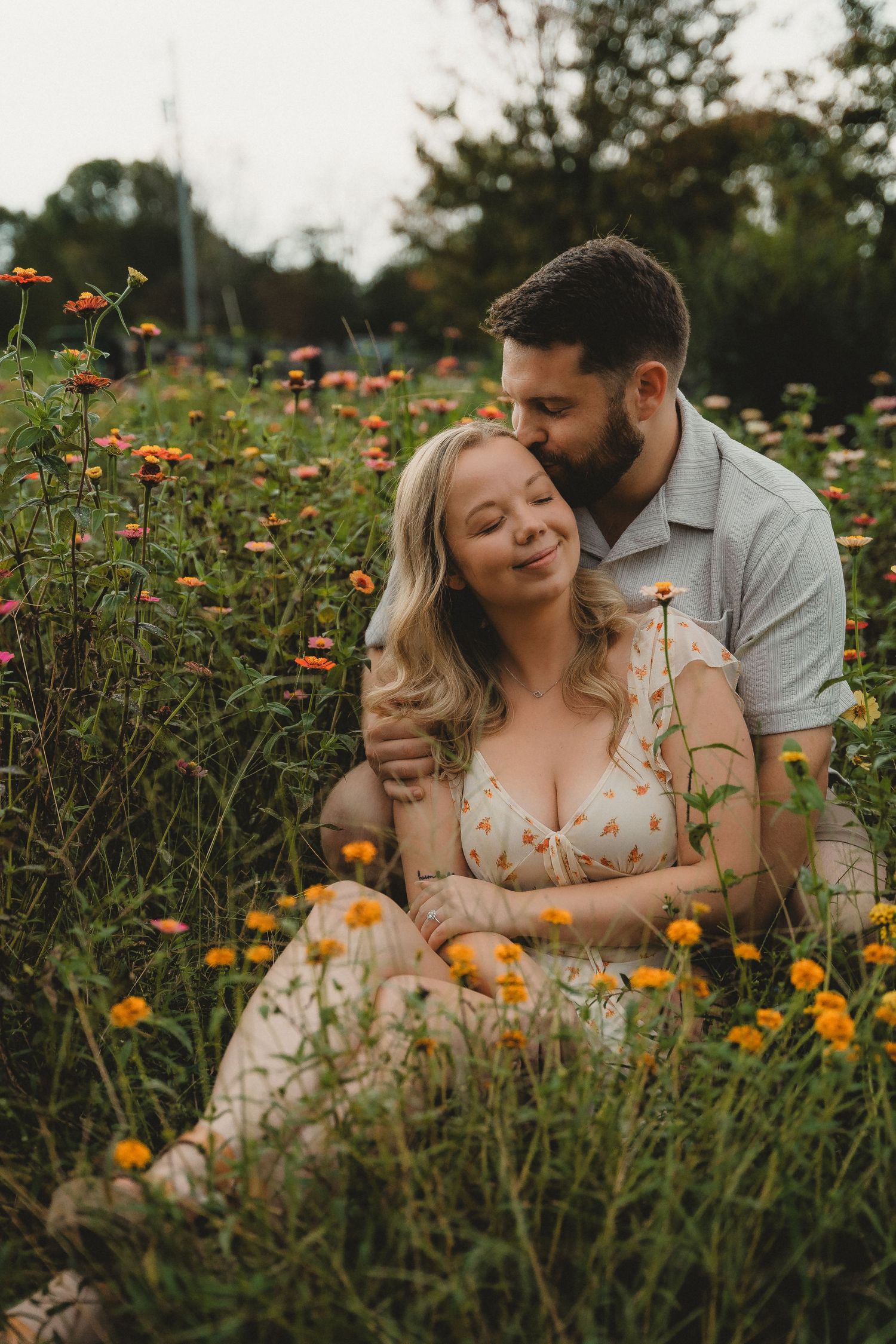 Couple sitting together in a vibrant wildflower garden during a romantic fall session.