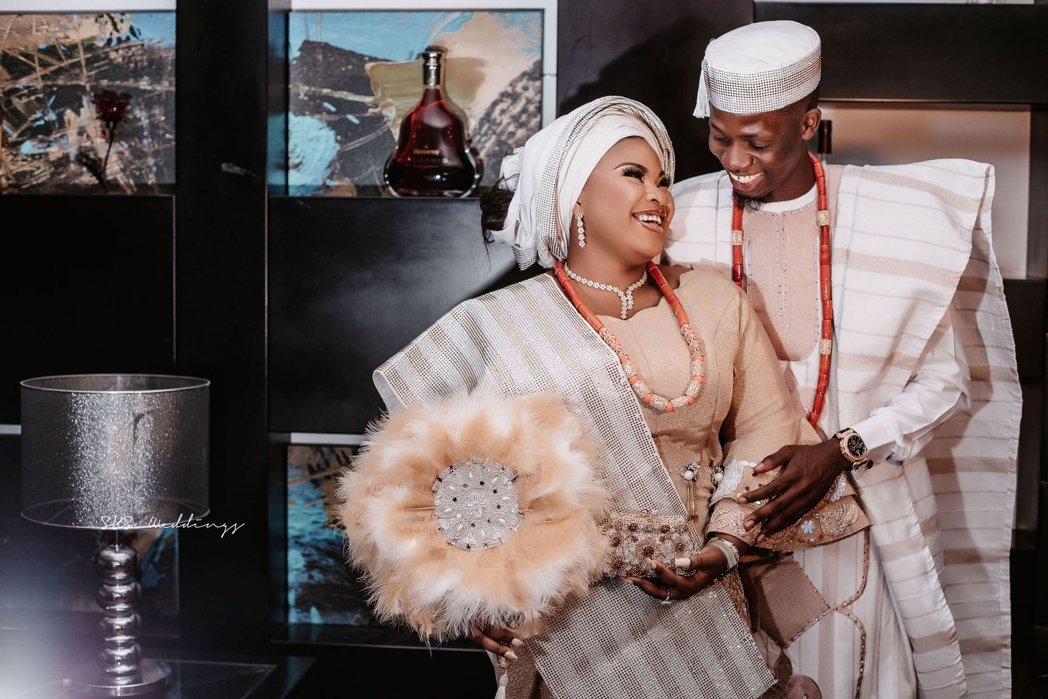 A traditional Nigerian wedding celebration captured with the couple in elegant white and cream traditional attire and accessories.
