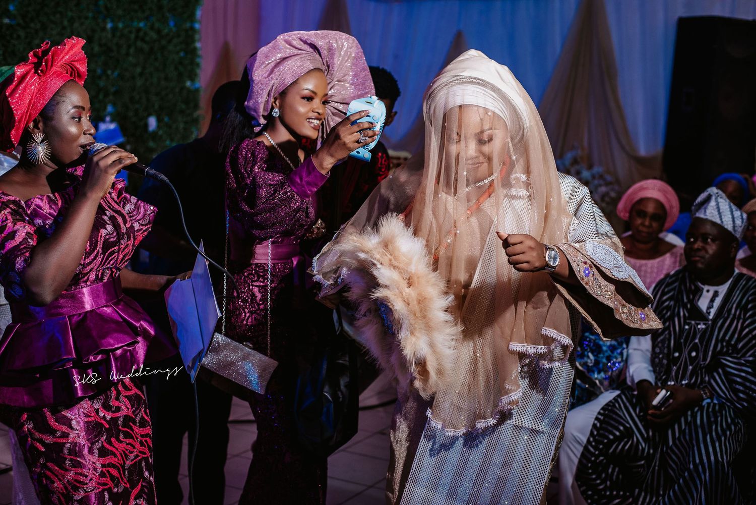 Colorfully dressed wedding guests celebrate with dancing and traditional attire at a lively Nigerian ceremony.