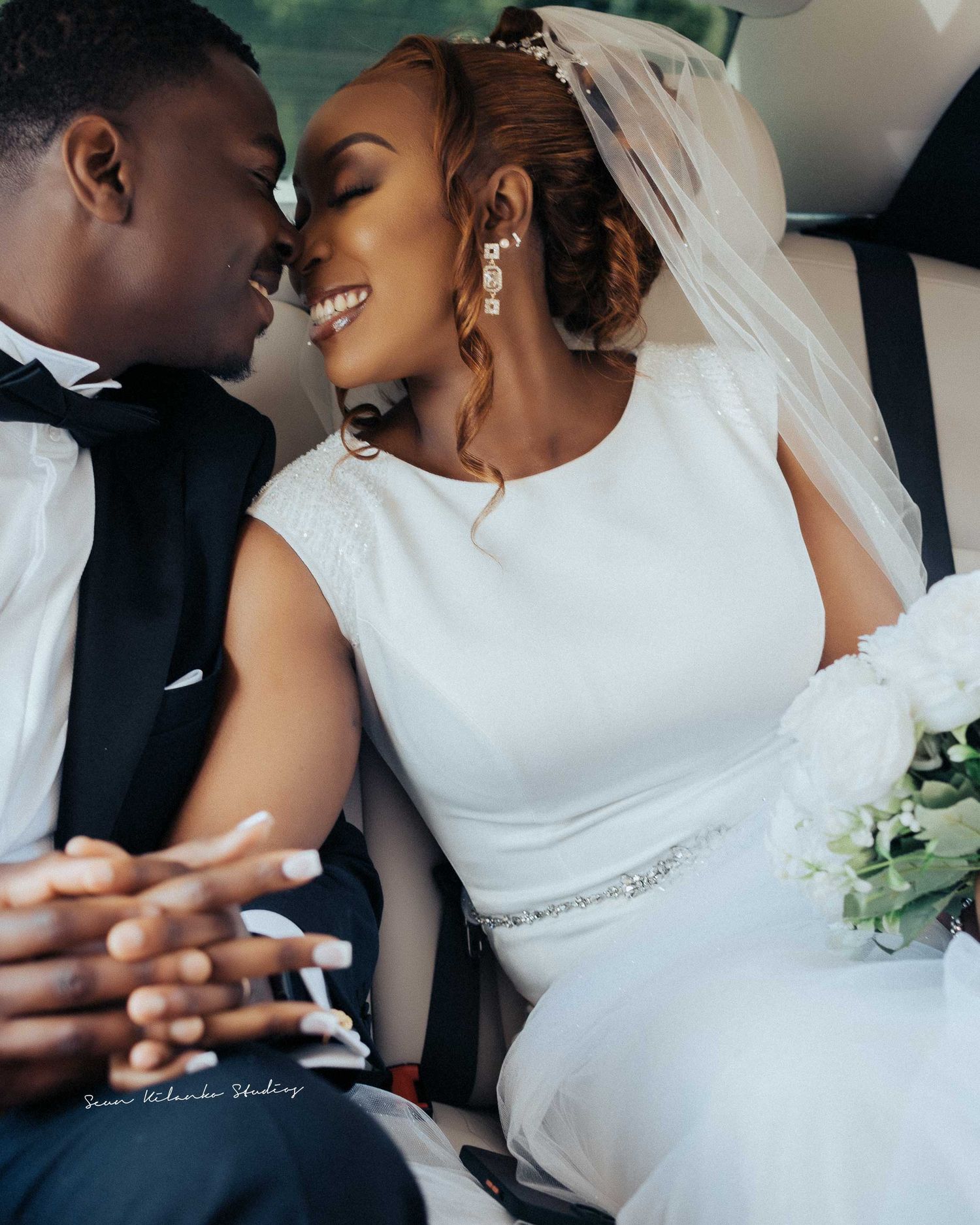An intimate wedding photo showing tender moments shared in the back of a car.