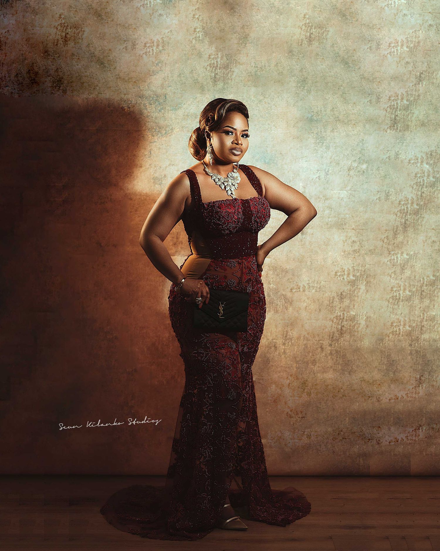 Sophisticated fashion portrait in a burgundy evening gown with crystal necklace.
