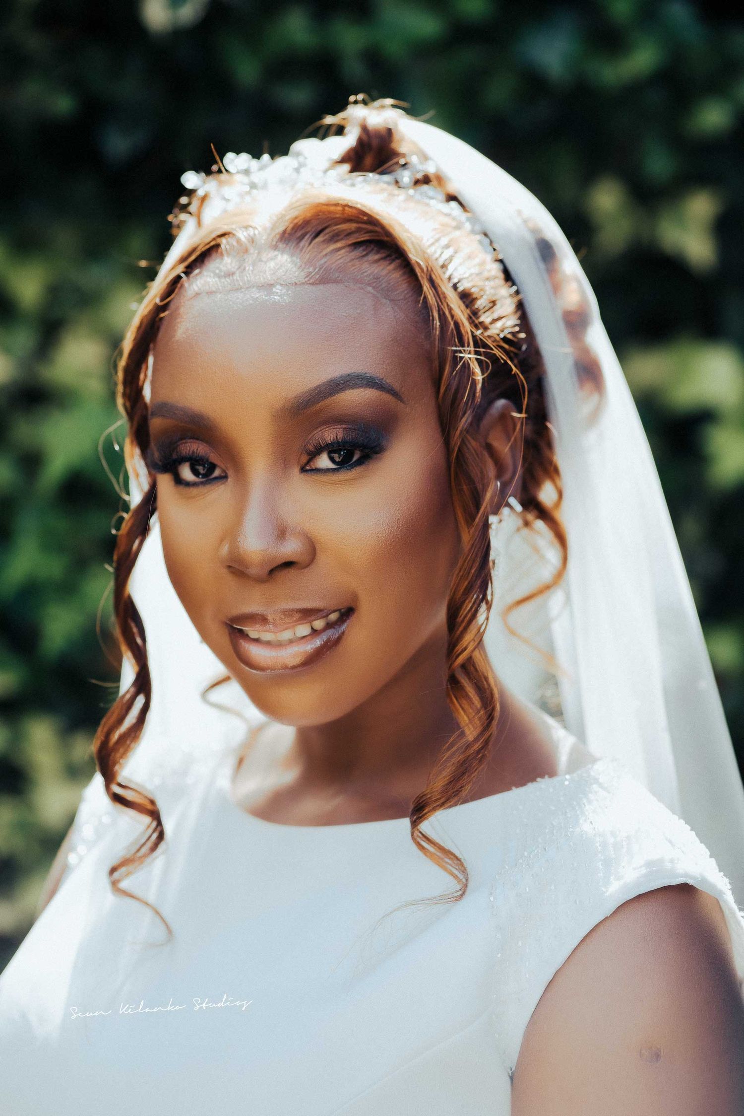 Close-up bridal portrait showcasing elegant makeup and delicate veil details.