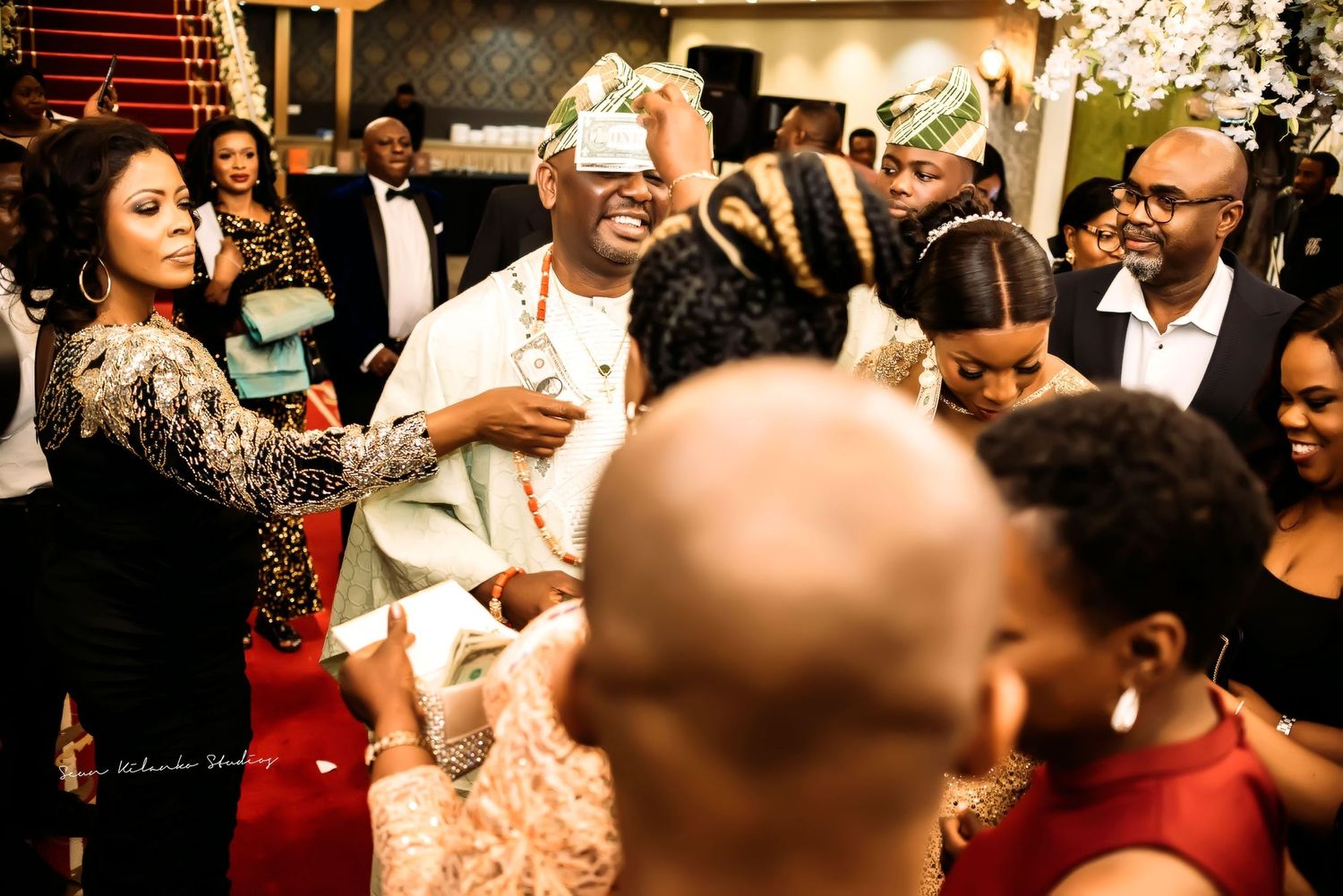 People celebrating and dancing at a lively wedding reception with warm lighting and festive atmosphere.