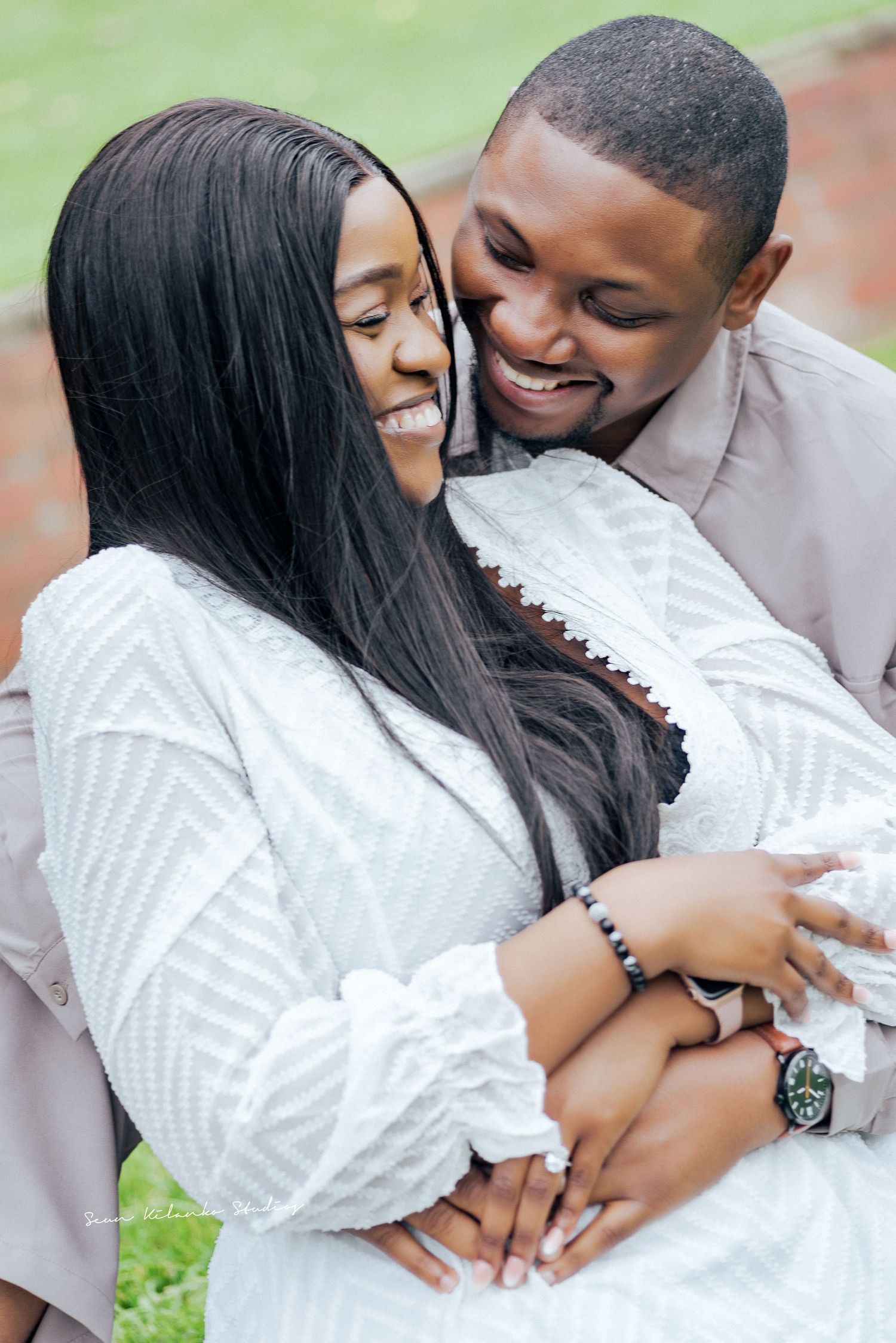Joyful couple embraces during outdoor portrait session.