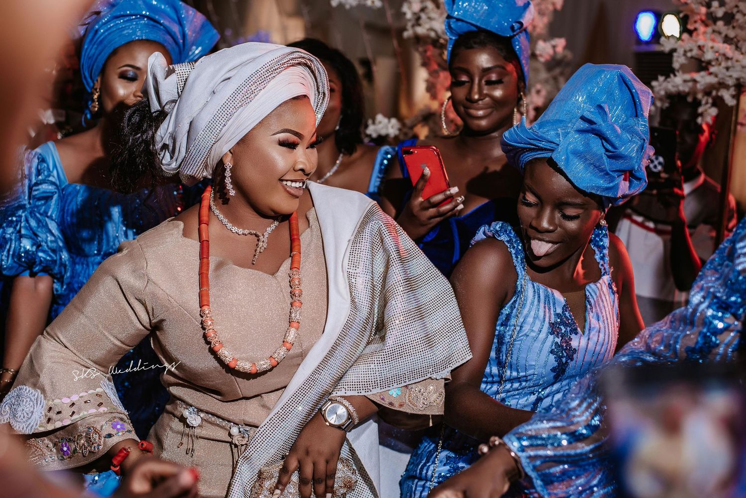 Traditional West African dancers in blue and white attire performing at a cultural celebration.