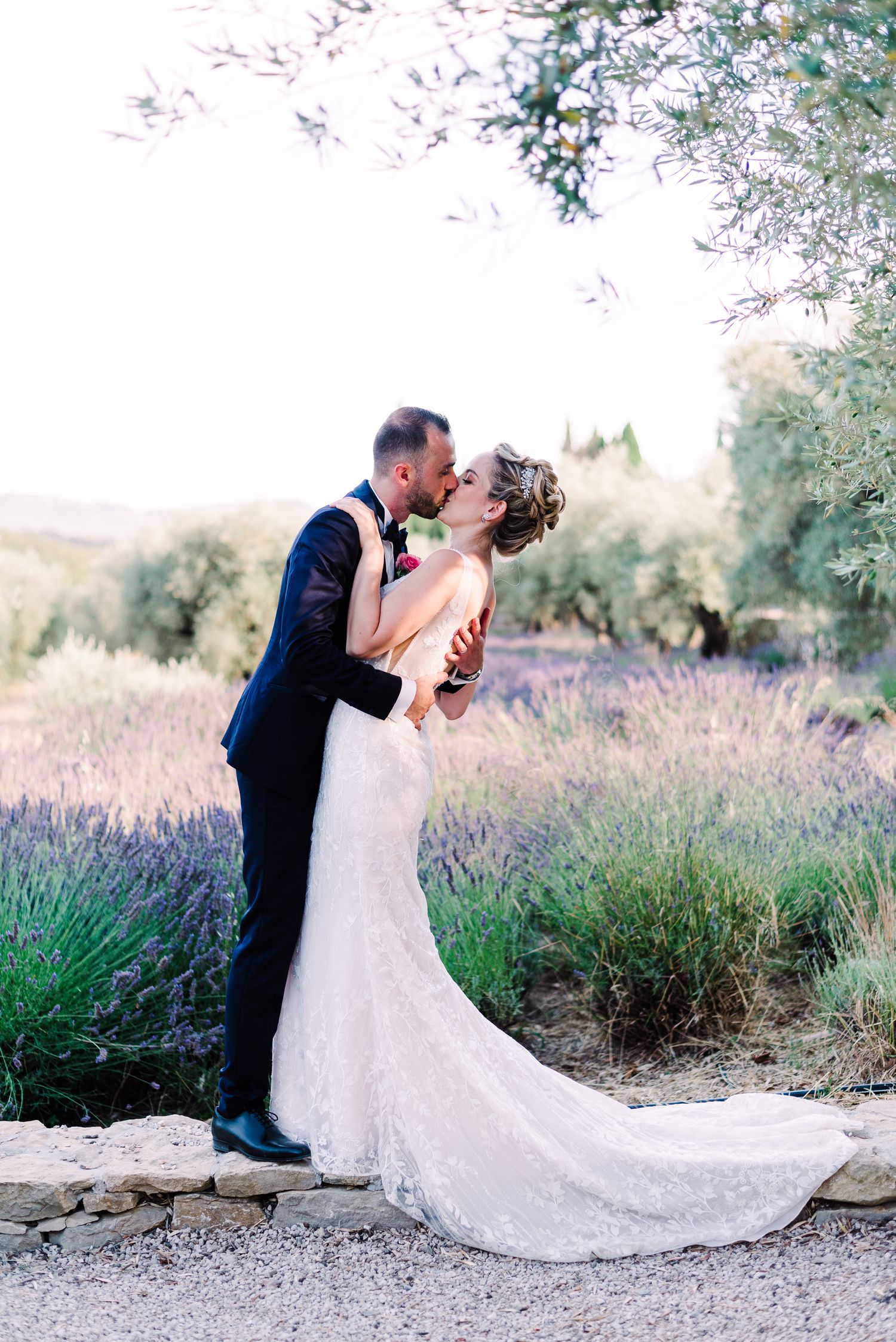 A romantic wedding portrait in a blooming lavender field with lace gown details.