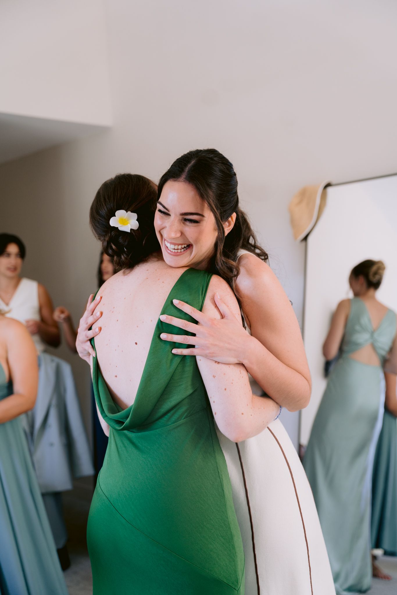 A series of candid moments showing bridesmaids in blue dresses and a person in green sharing emotional embraces.