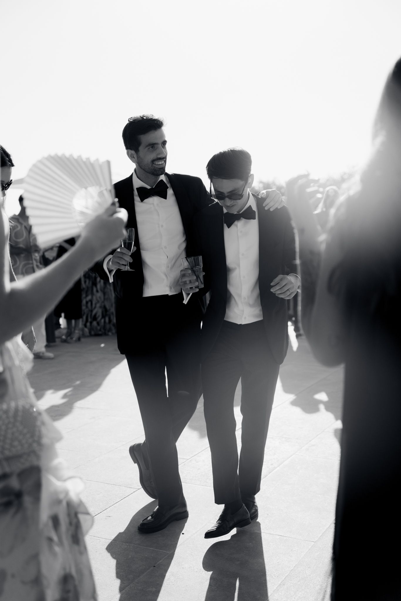 Black and white photo showing people dancing at a formal event with their legs and feet in motion.