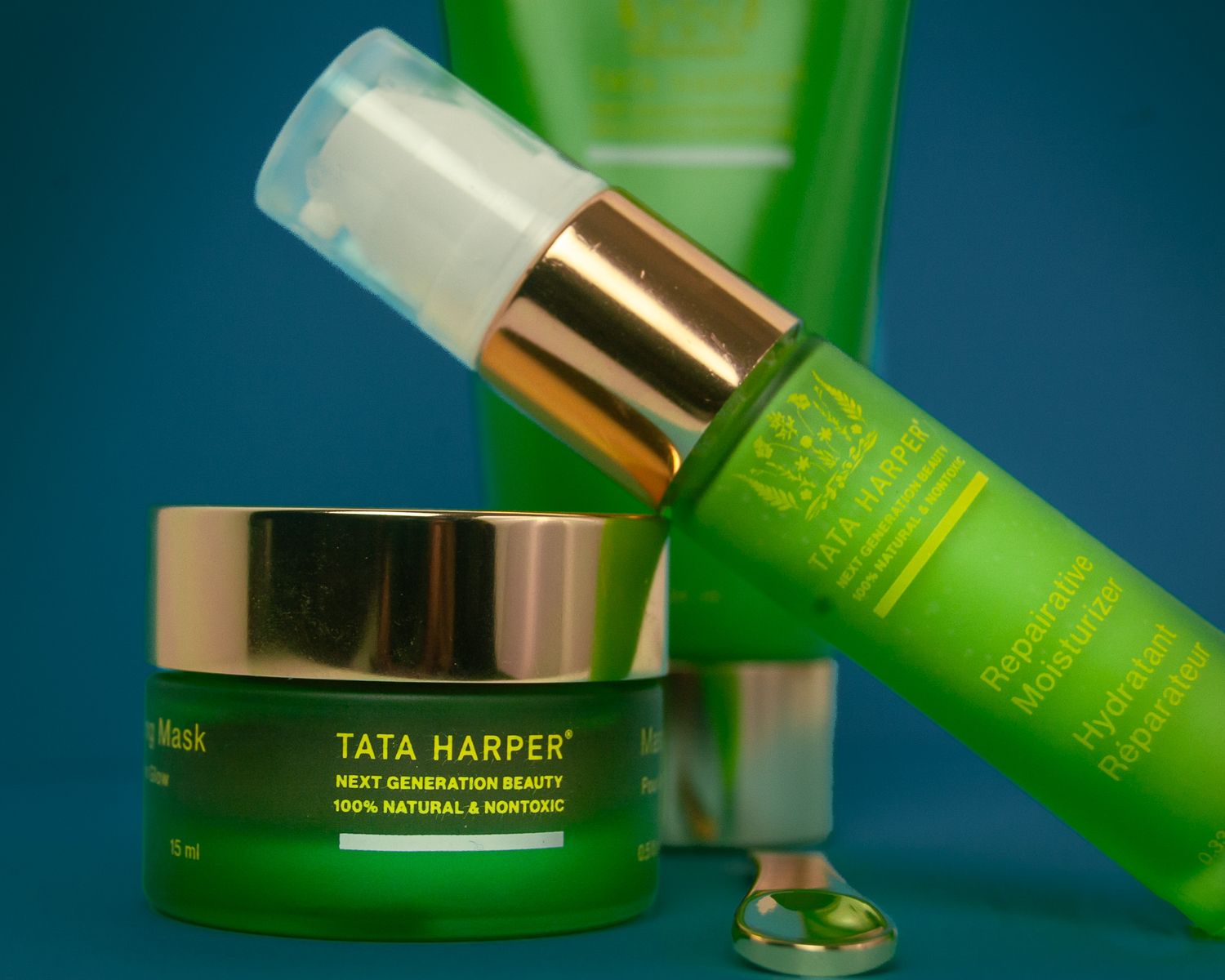 Green and gold luxury skincare products from Tata Harper against a dark background with beauty treatment containers.
