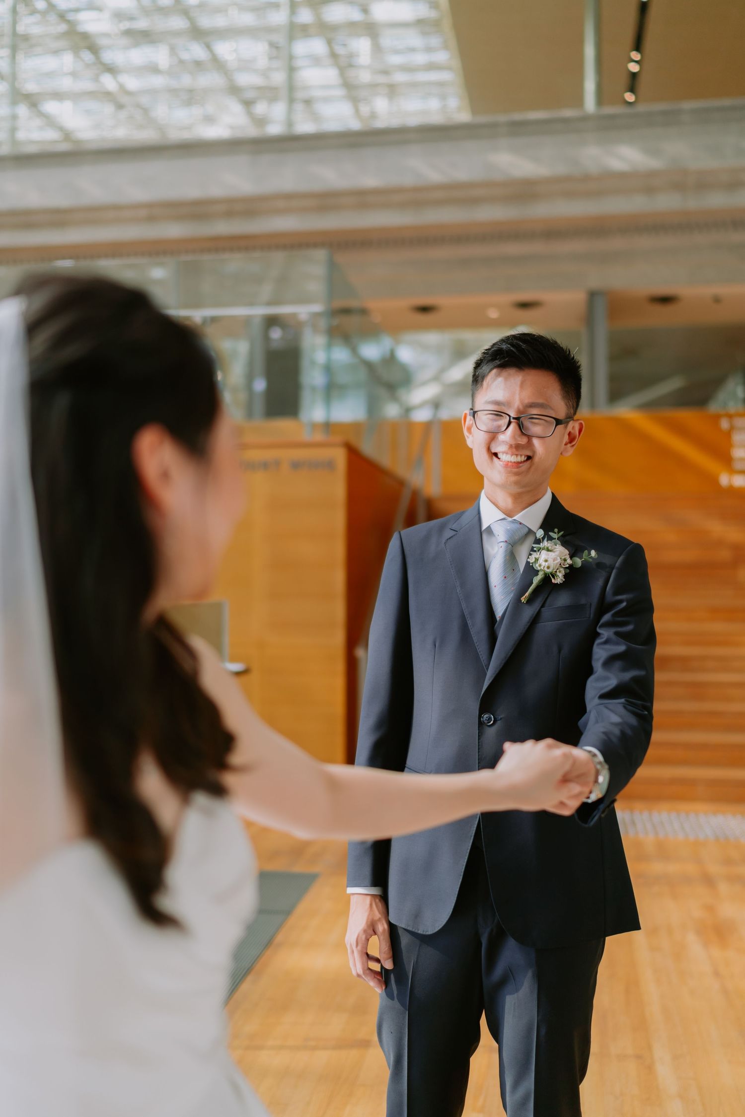 Groom smiling warmly at his bride during a first look moment inside a modern venue.