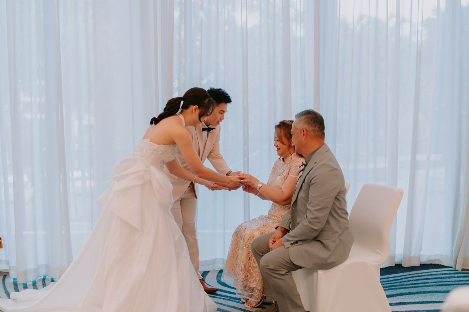 Bride and groom exchanging vows with seated guests during an elegant indoor wedding ceremony.