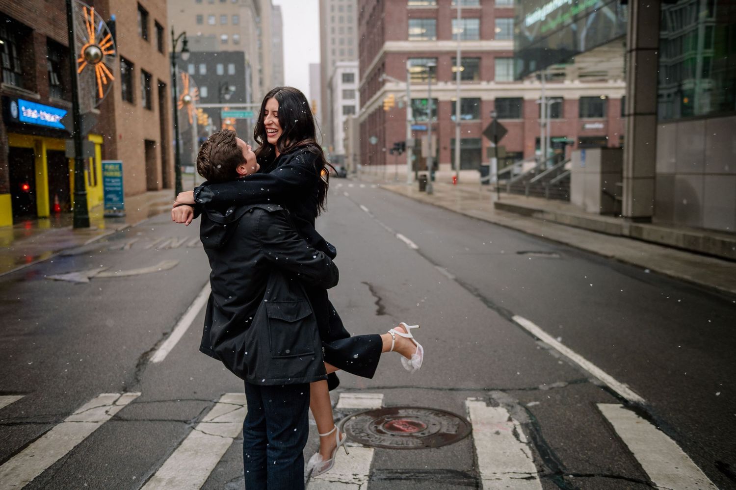 A couple shares a playful moment while dancing in the middle of an empty city street.