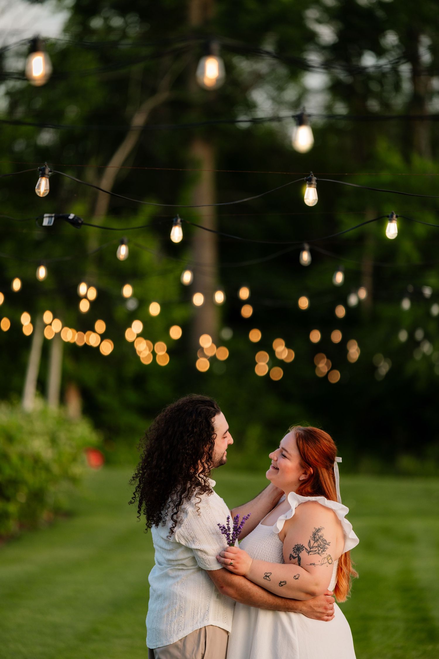 String lights create a romantic ambiance in an outdoor garden setting at dusk.