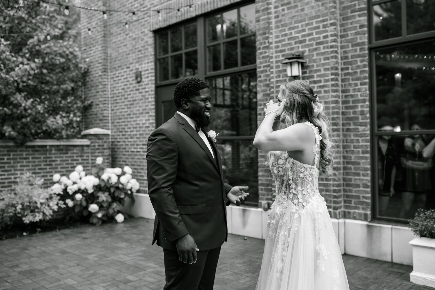 Black and white wedding photo collage showing intimate moments between a couple at a brick venue setting.