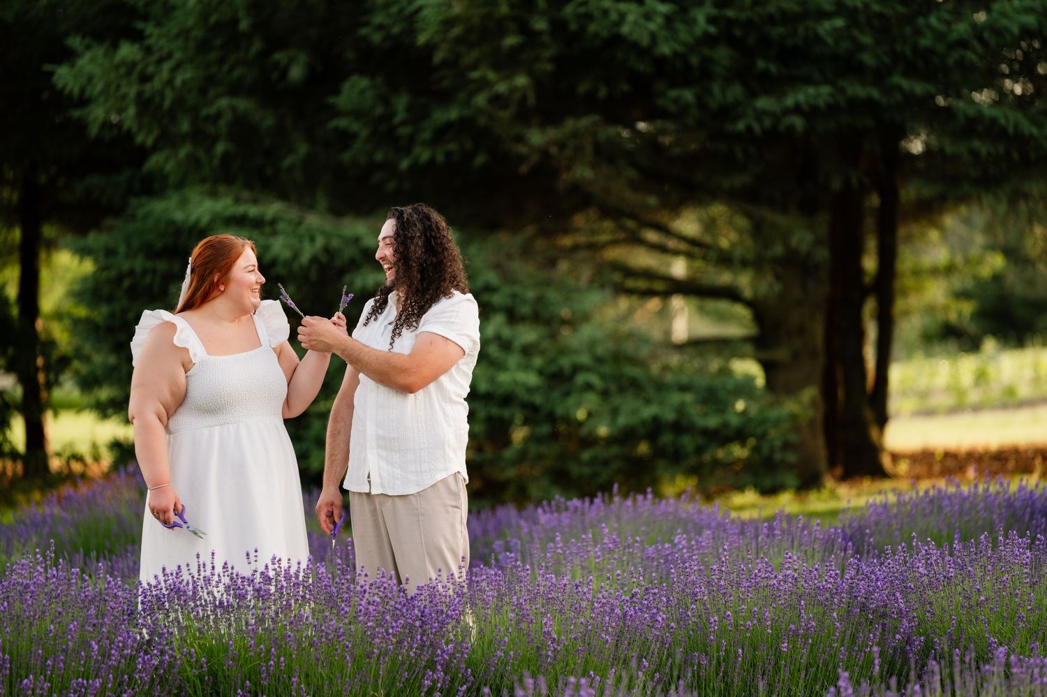 A couple shares joyful moments together in a field of purple lavender.