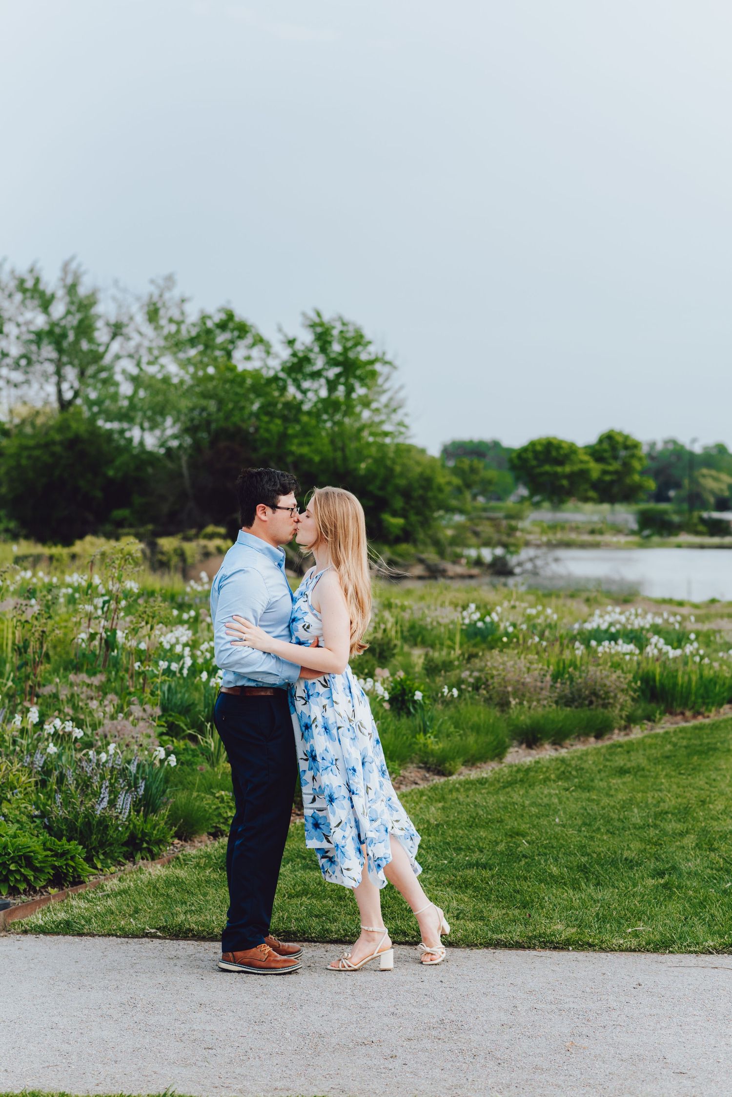 A romantic moment shared by a lake surrounded by spring wildflowers.