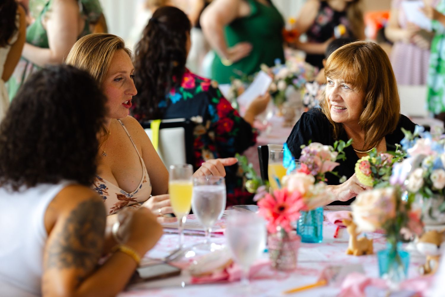 Guests enjoying a celebration at decorated tables with floral centerpieces and turquoise accents.