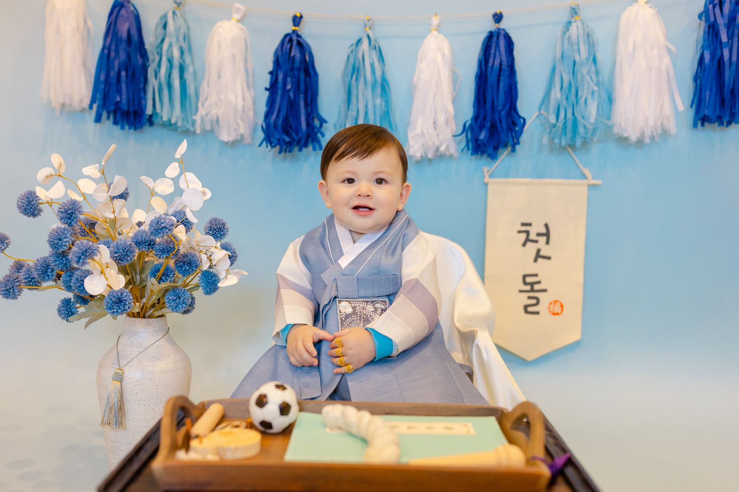 Blue and white decorations adorn a festive party setting with tassels and balloons.