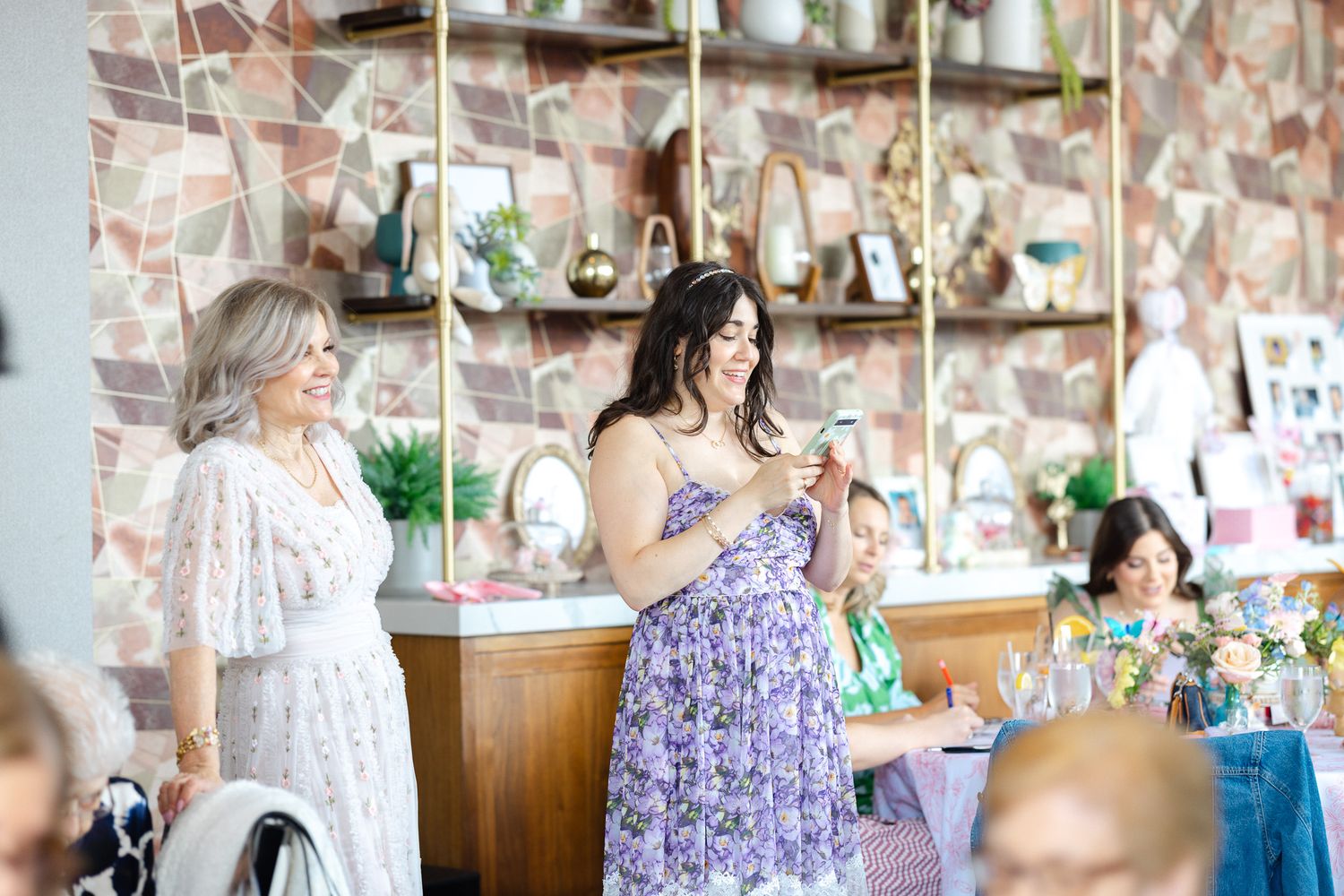 A series of photos showing a person in a purple dress opening a gift box in a room decorated with pictures.