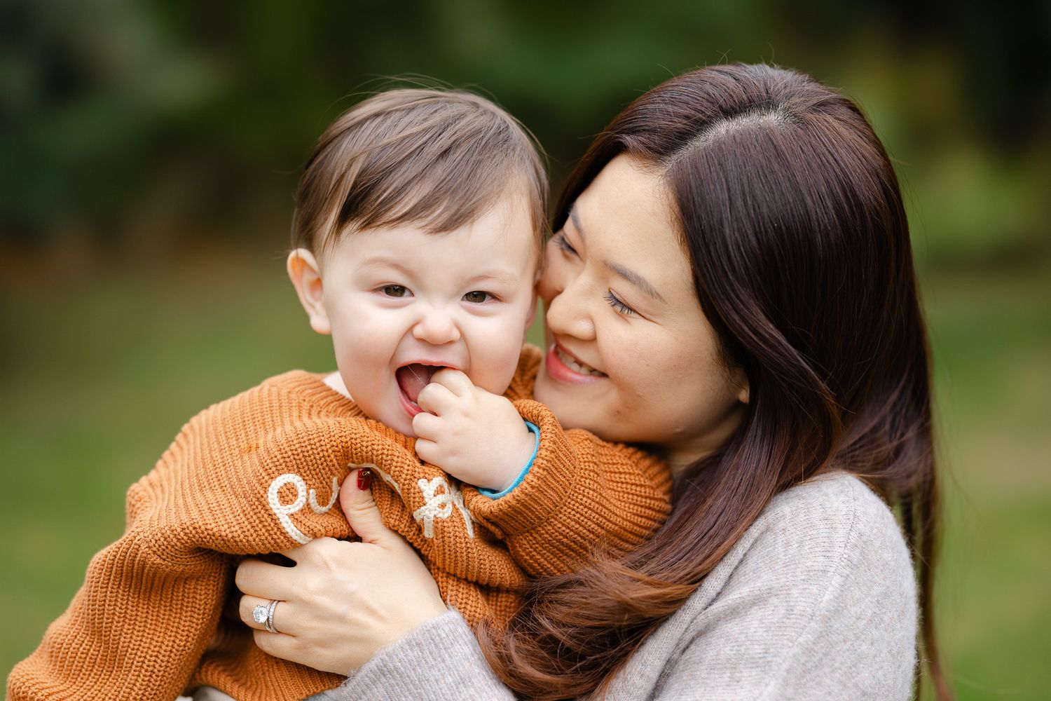 Sweet family interaction series photographed outdoors with natural lighting and autumn tones.