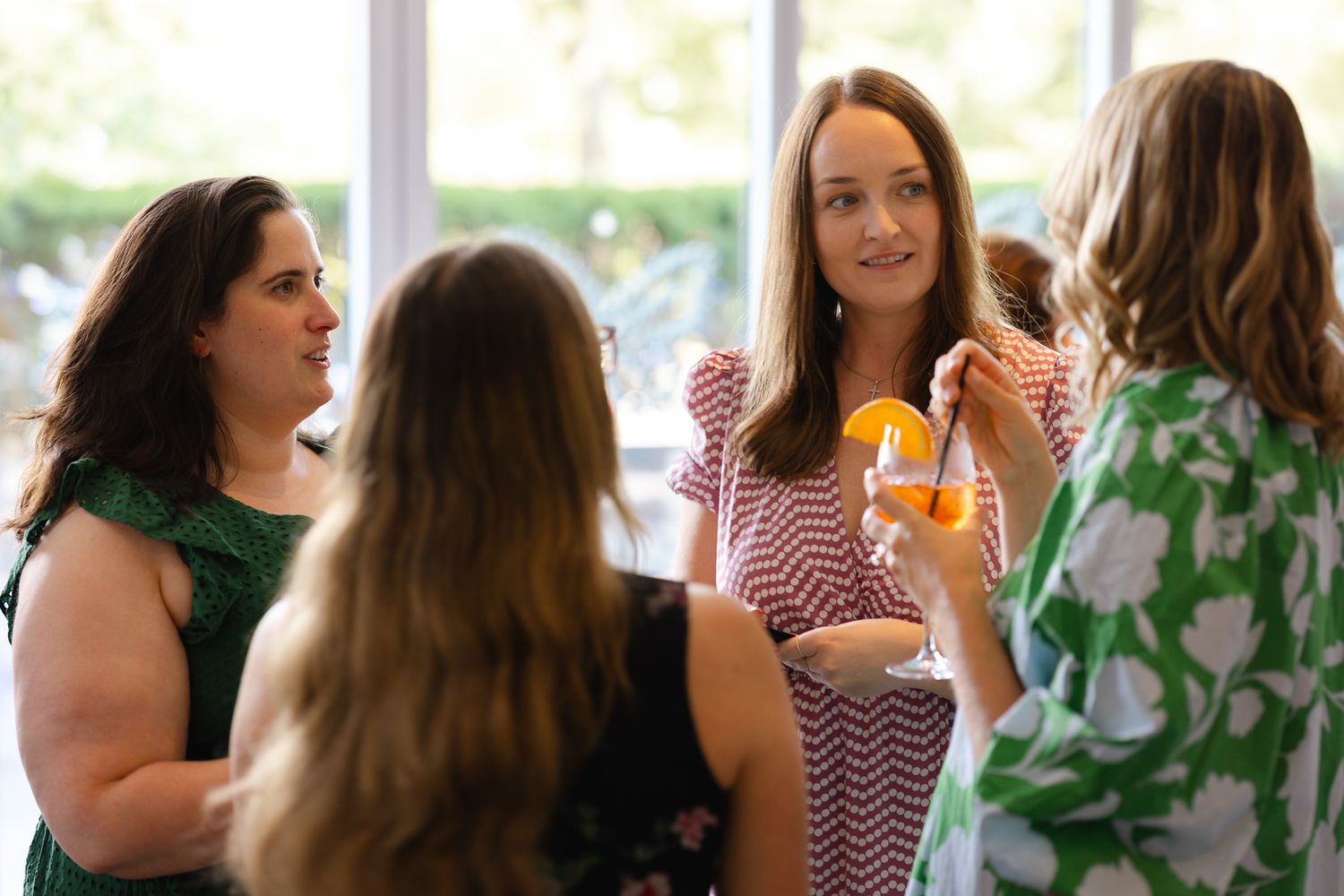 A group of people gather together in a bright indoor space for a social event or celebration.