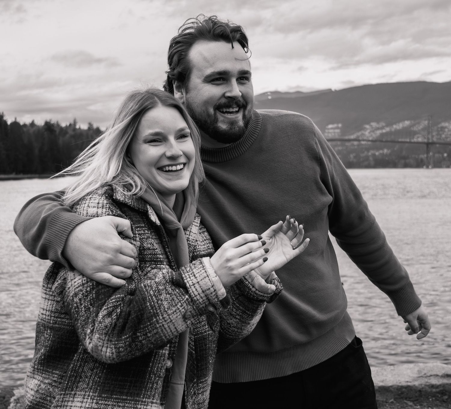 woman happily smiles as fiance gives her a side hug