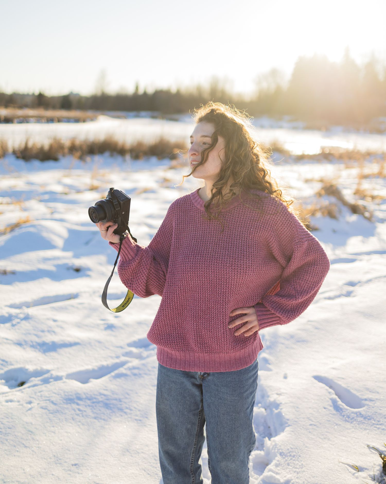 a woman holding a camera in the snow