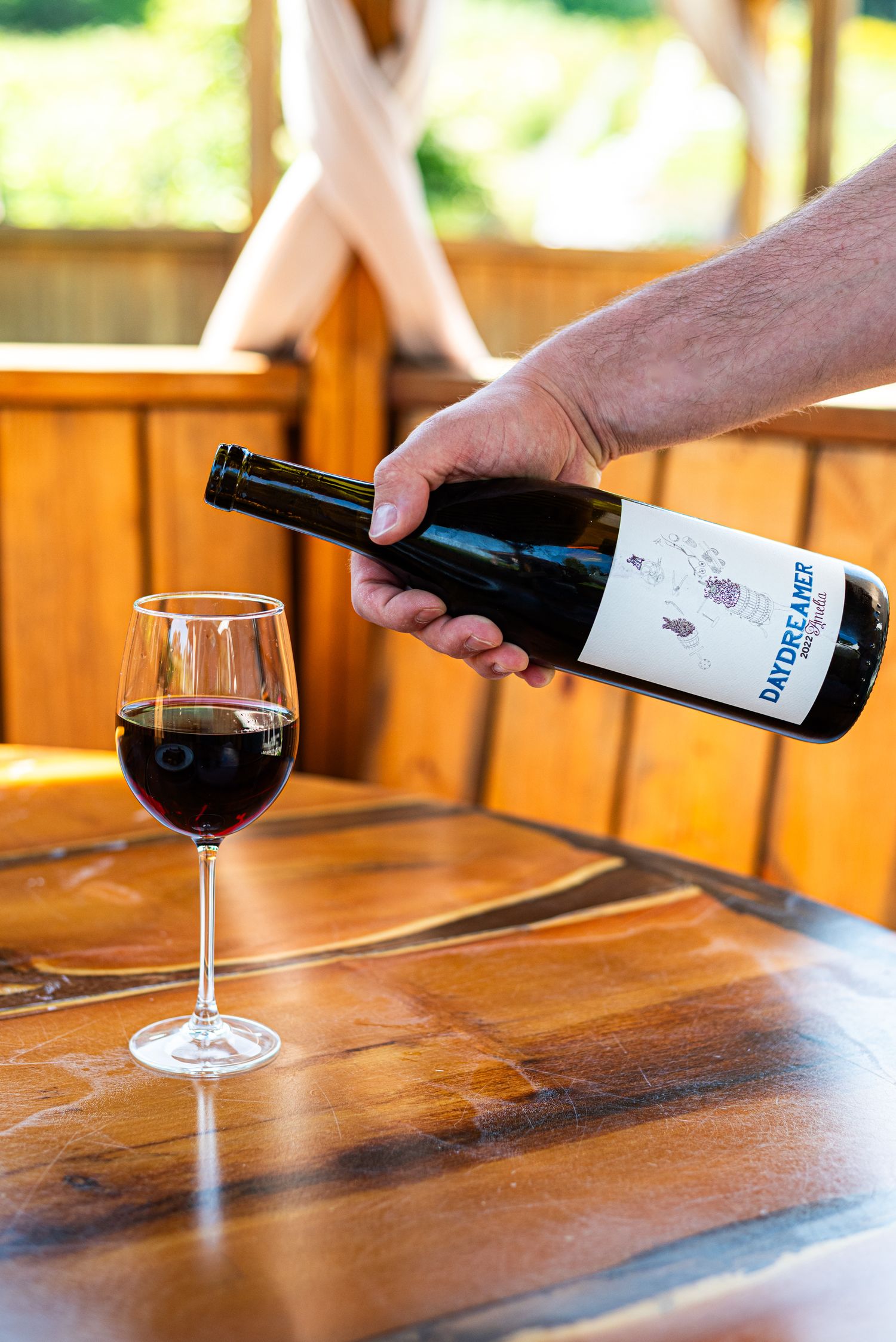 man pouring wine in a glass