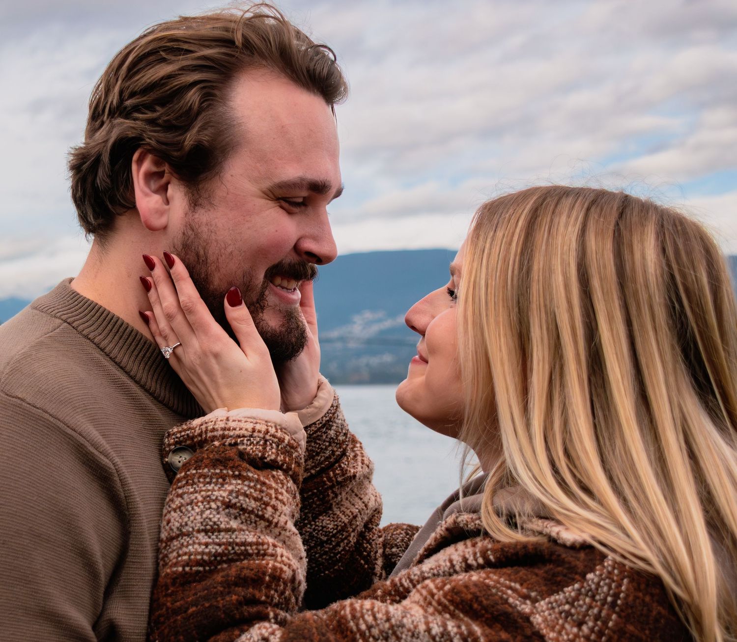 newly engaged couple goes in for a kiss