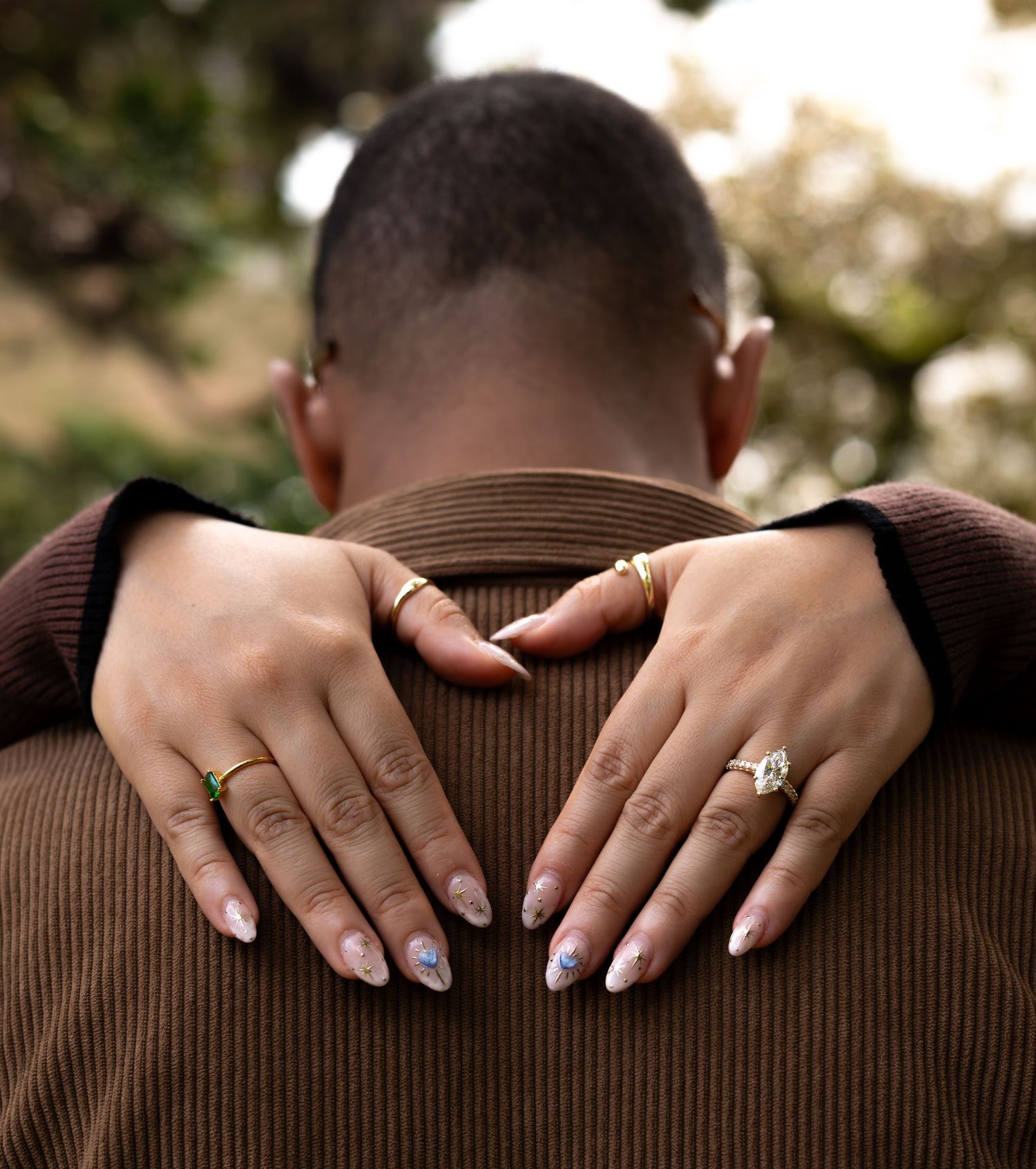 womans hands over mans neck showing off her ring