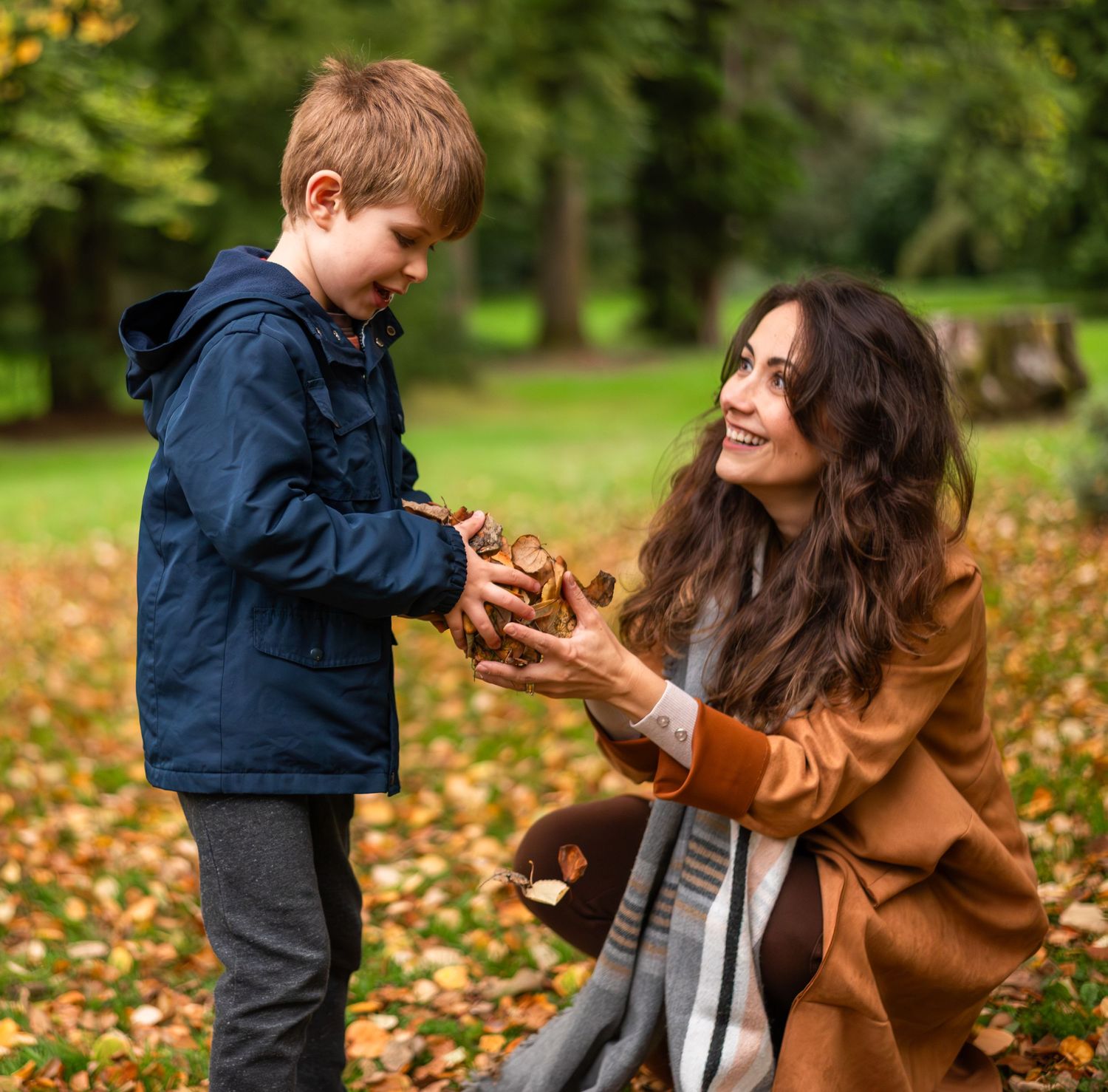 mom and son playing with leaves