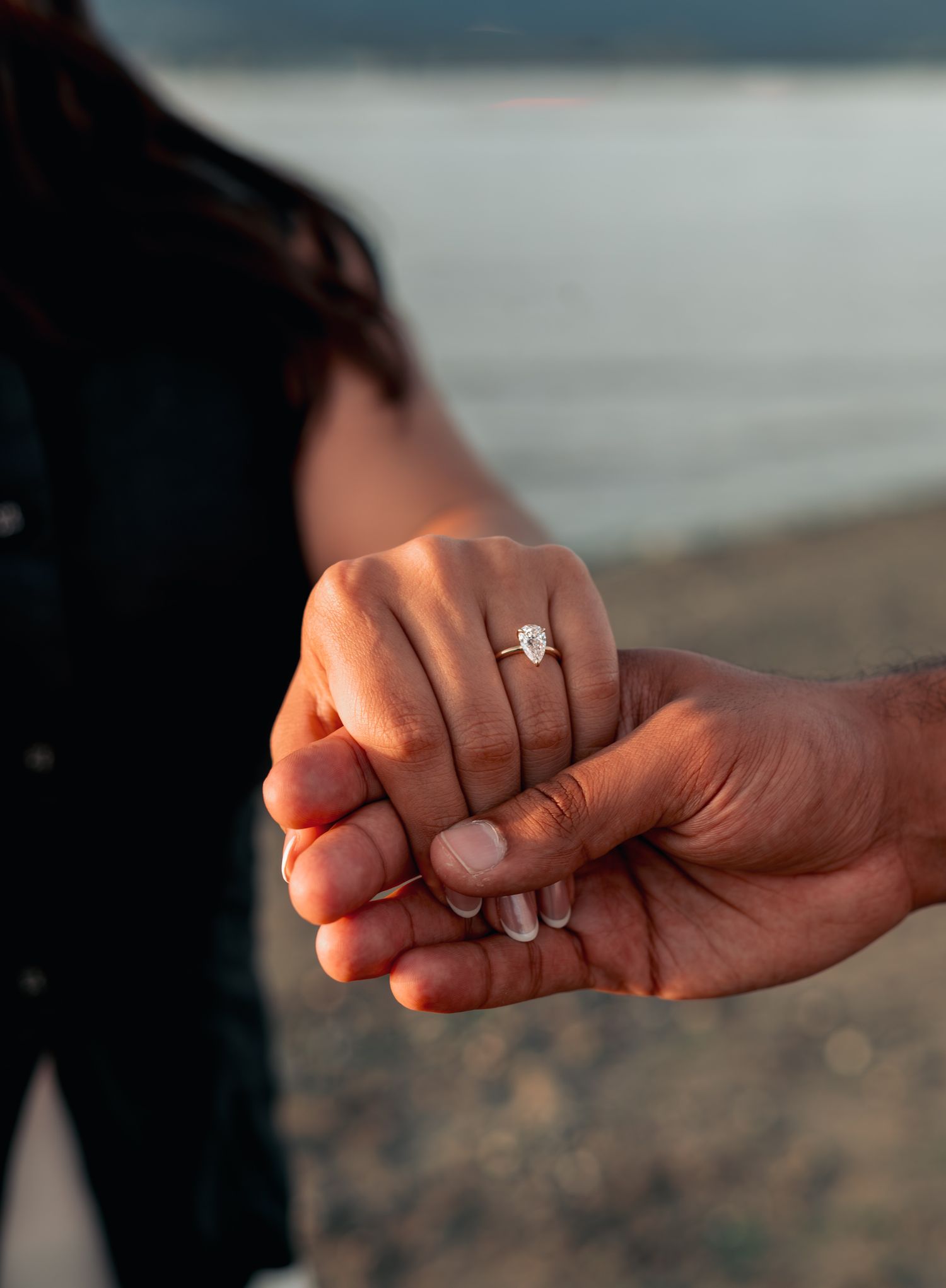 man holding womans hand with engagement ring