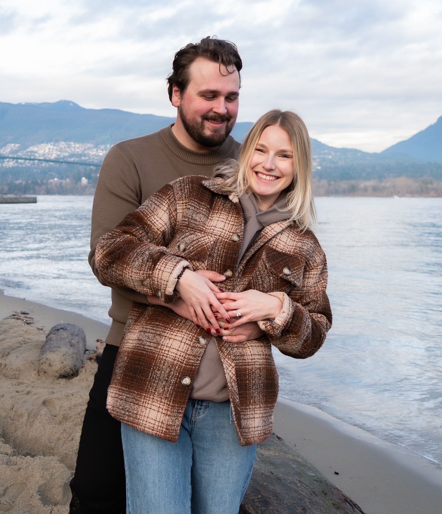 couple wrapped in eachothers arms newly engaged