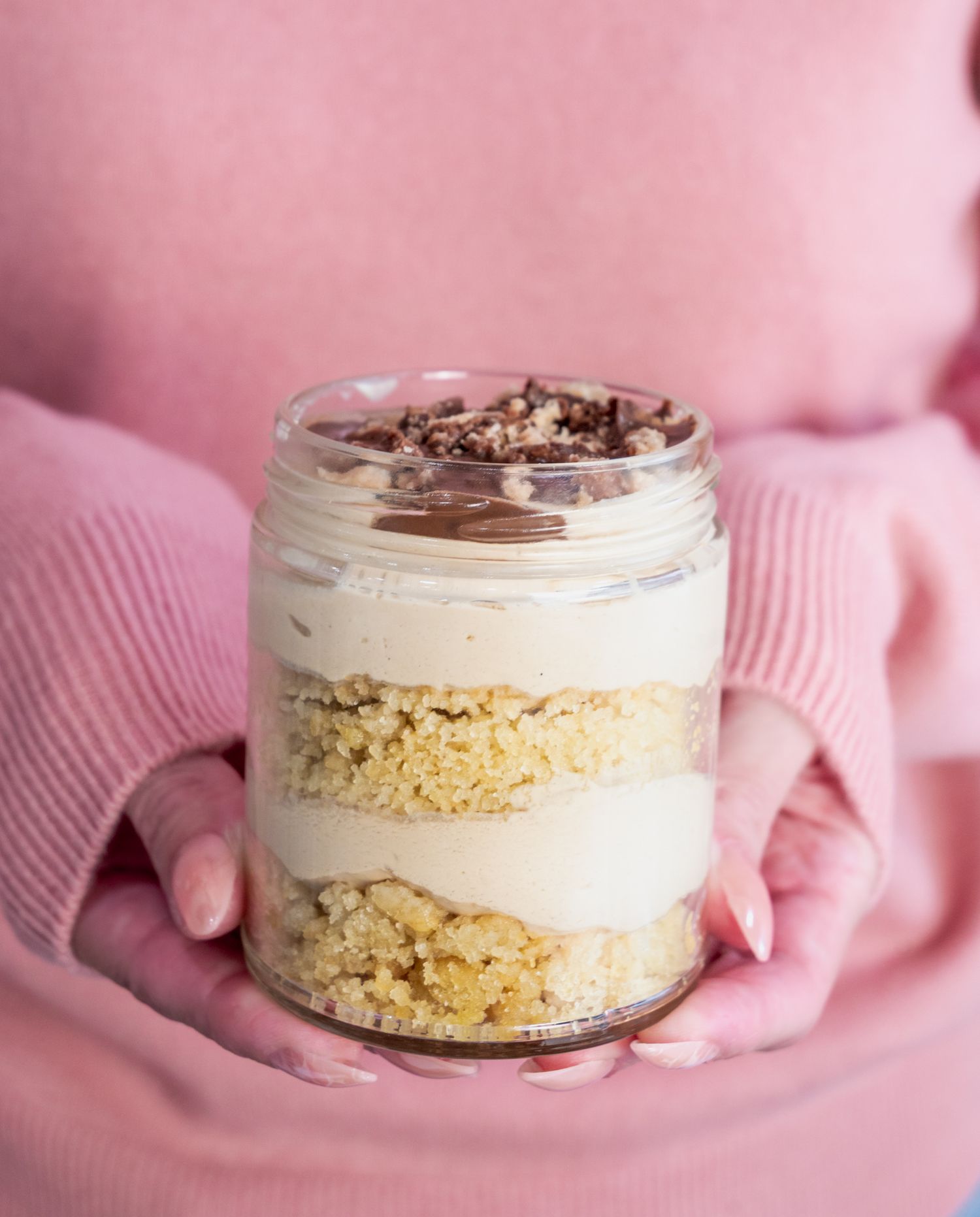 a woman holding a cake jar.