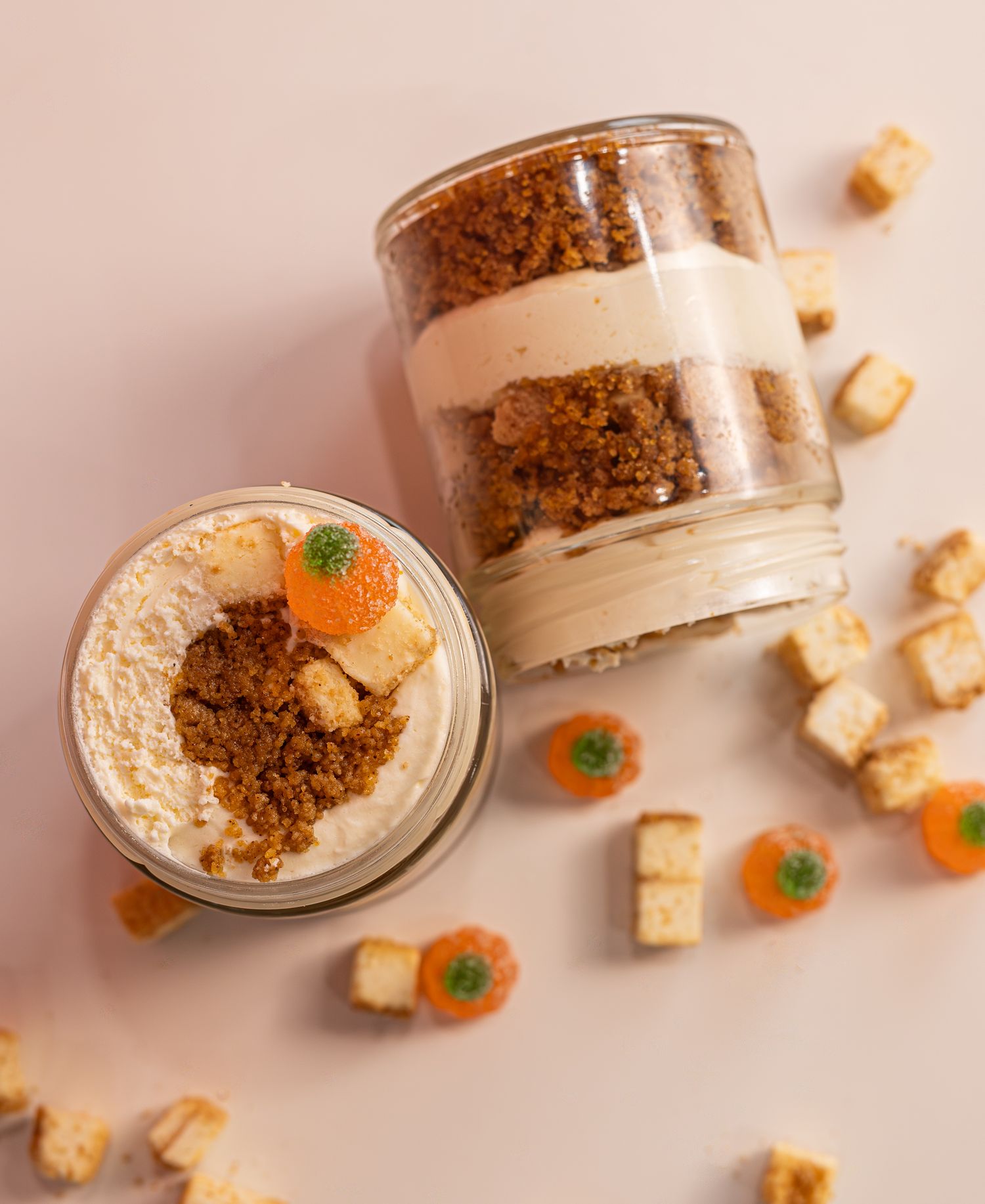 a photo of pumpkin cheesecake cake jars with pieces of cheesecake and pumpkin gummies