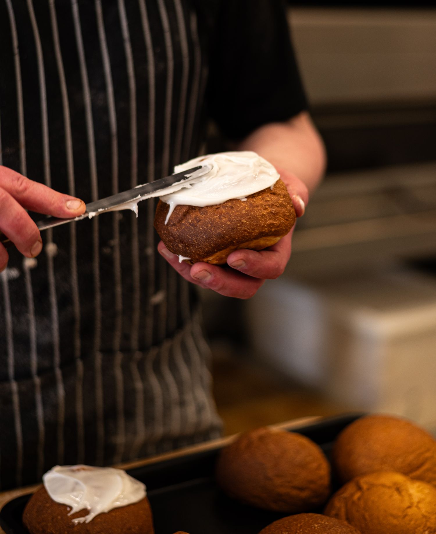 a baker puts icing on paska buns