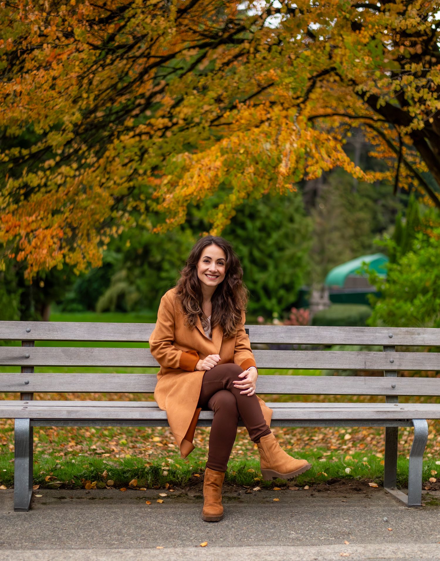 woman sitting and smiling under a colourful tree