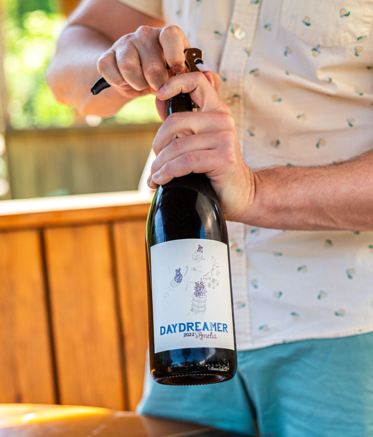 photo of a wine bottle being opened in summer