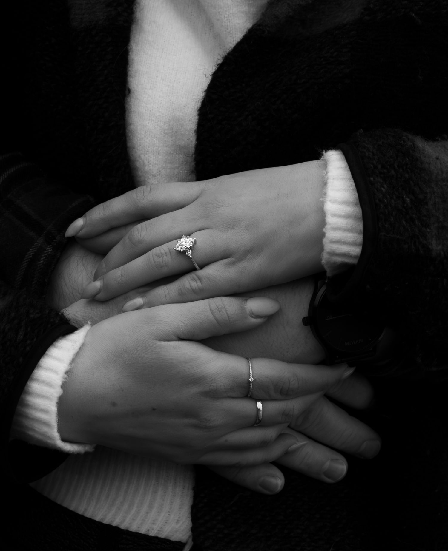 man holding womans waist with her hands over his showing off her ring
