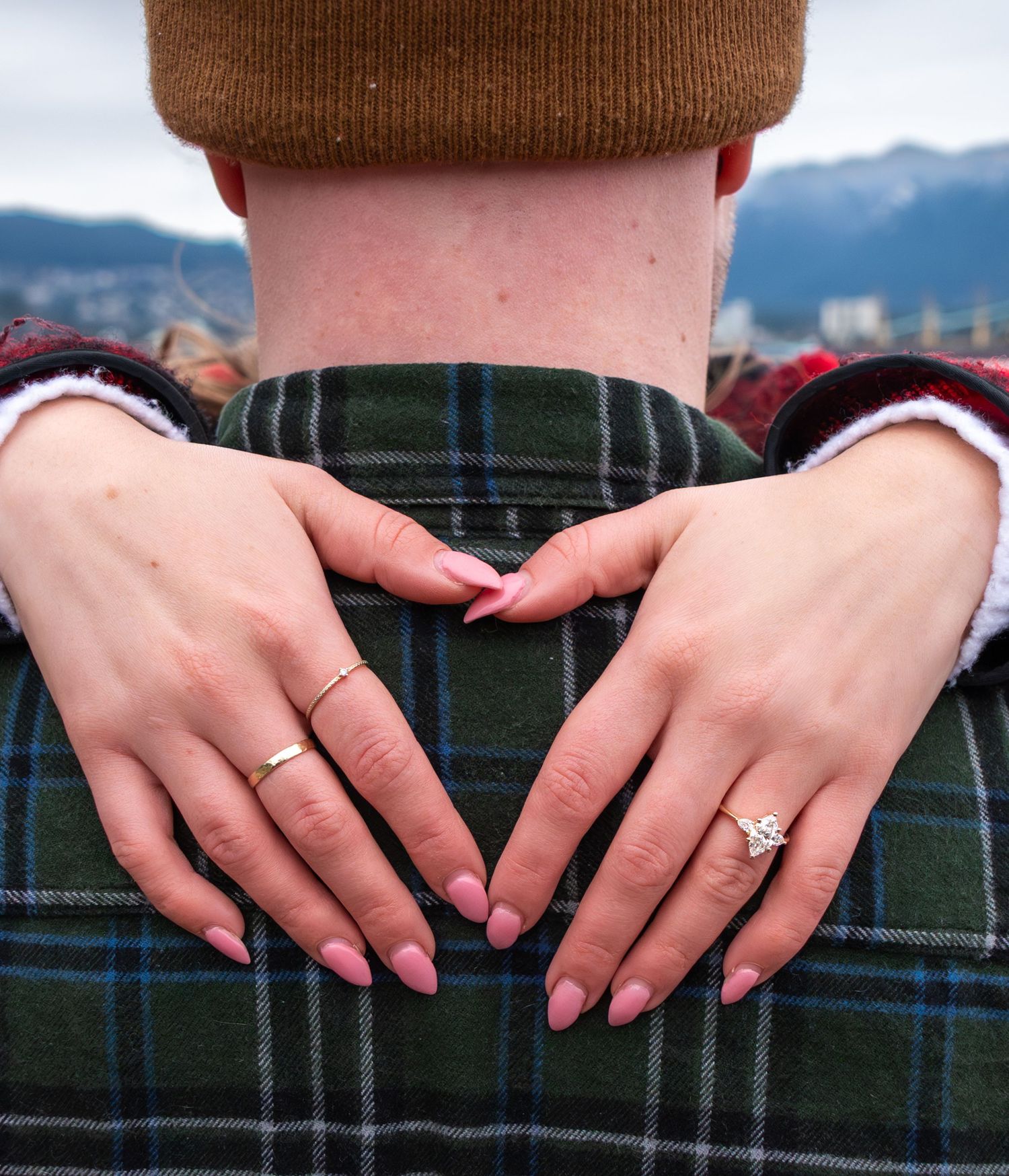 womans hands over mans neck showing off her ring
