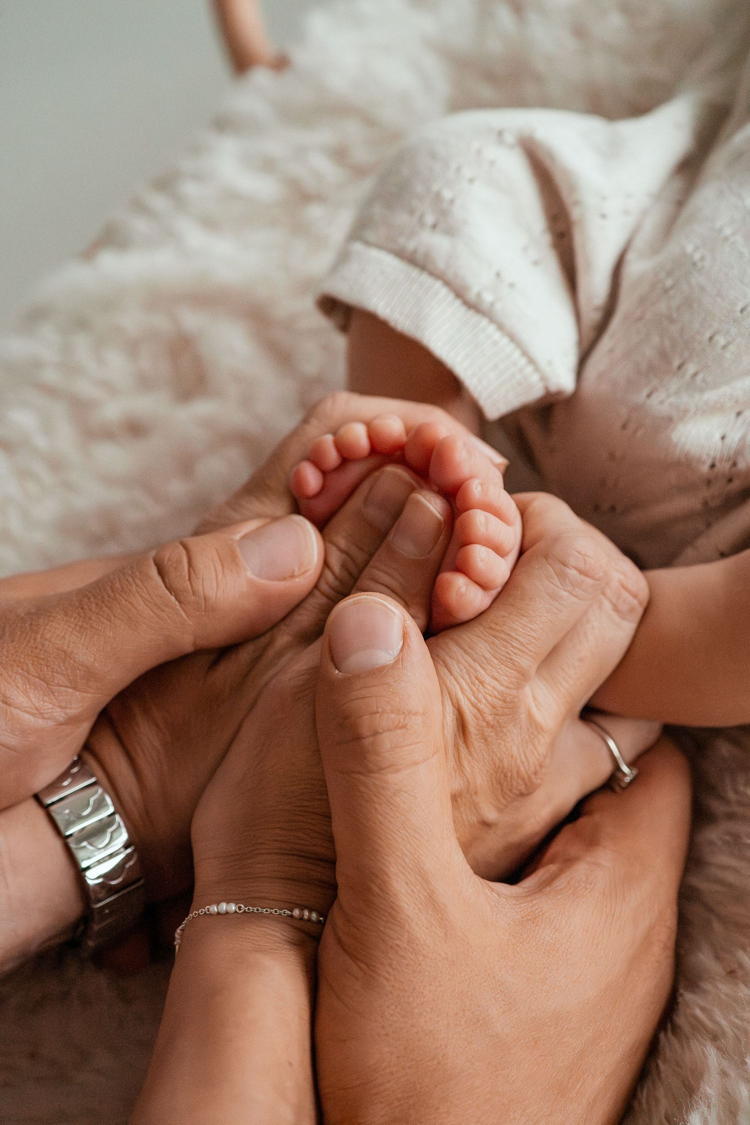 A series of photos showing a baby's tiny hand grasping an adult's finger wearing a ring, captured in warm natural light.