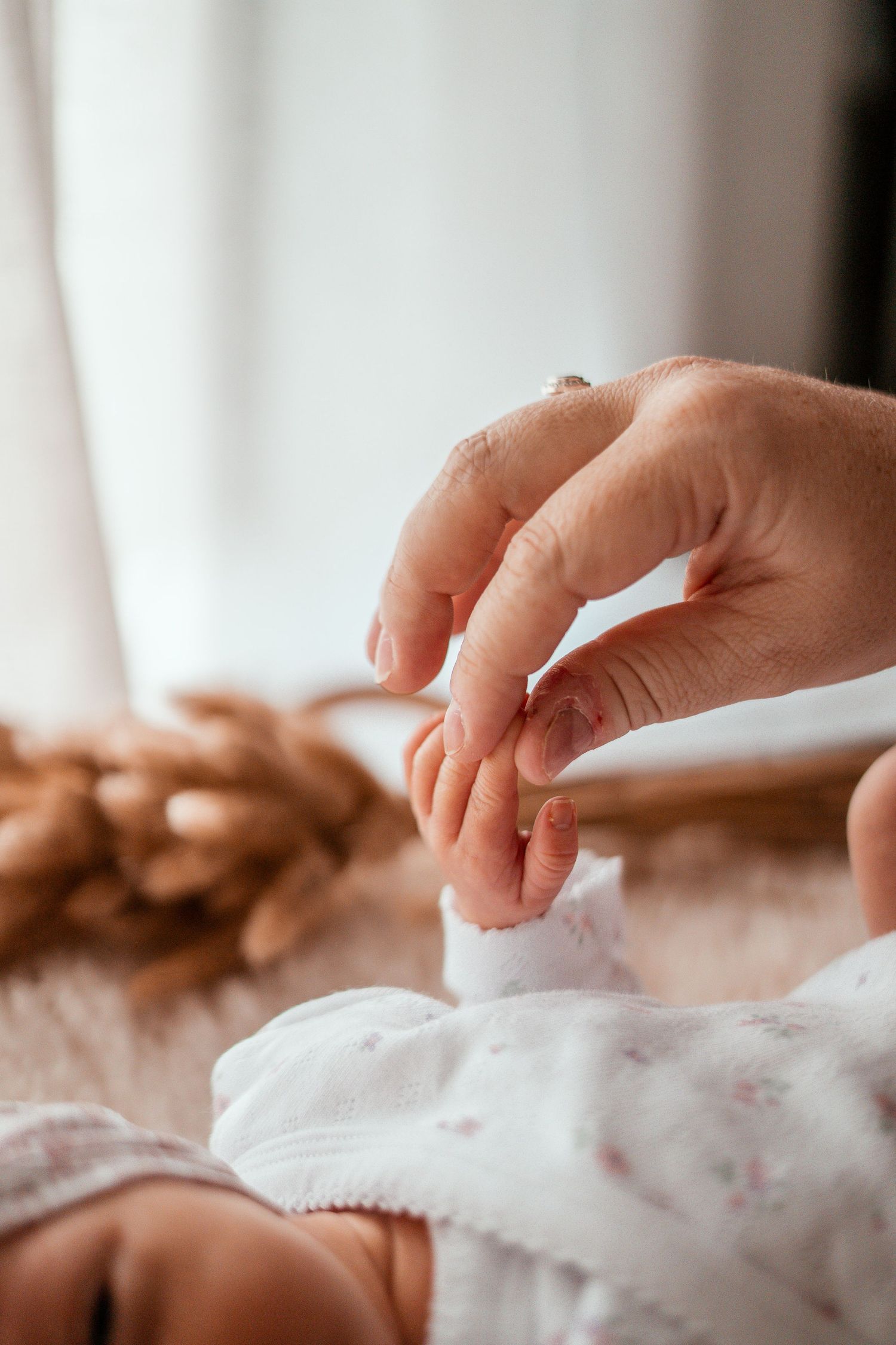 Close-up of hands kneading and shaping raw dough on a floured surface in soft natural light.
