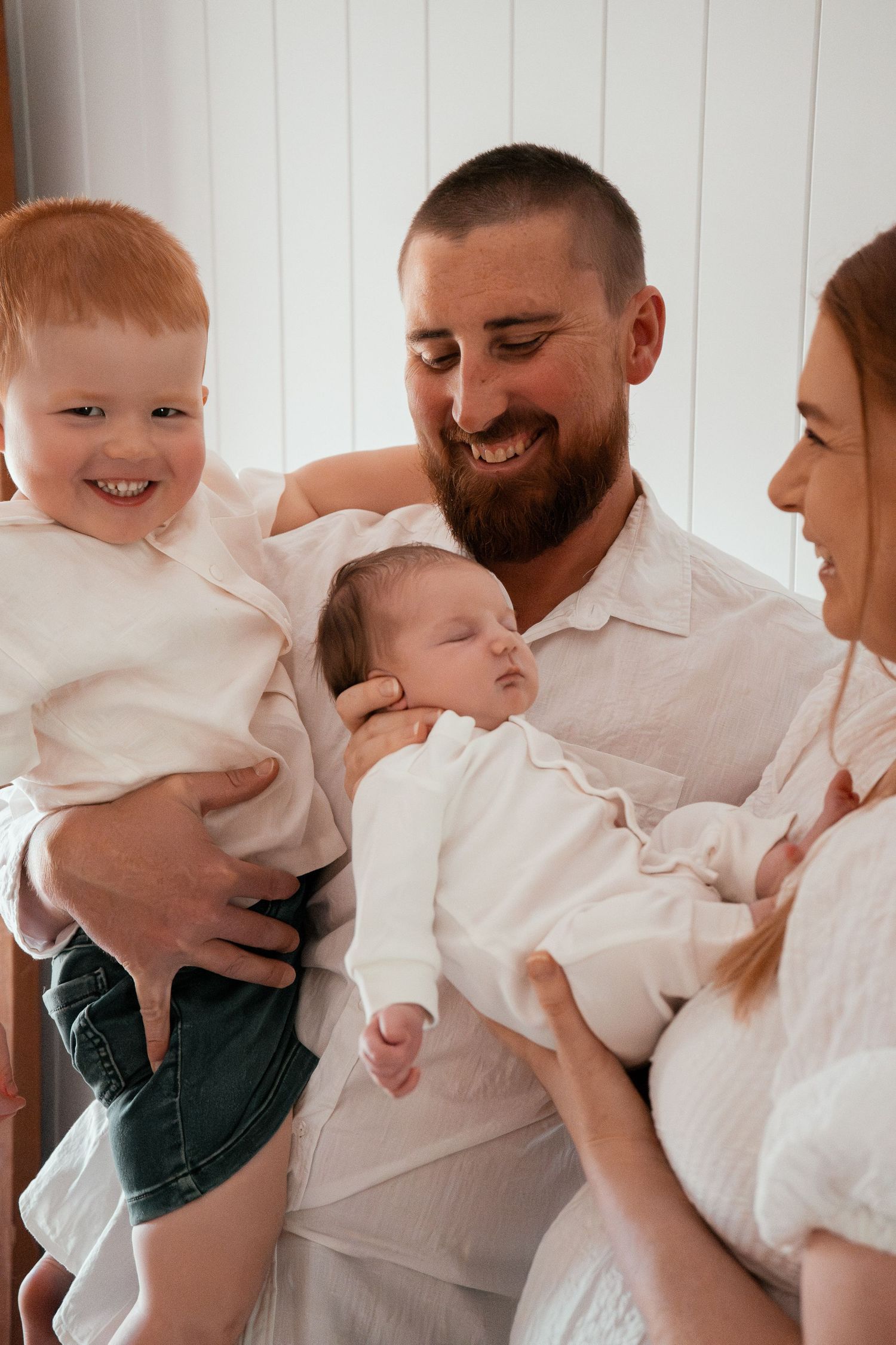A family wearing white clothes shares joyful moments together in a series of candid photos.