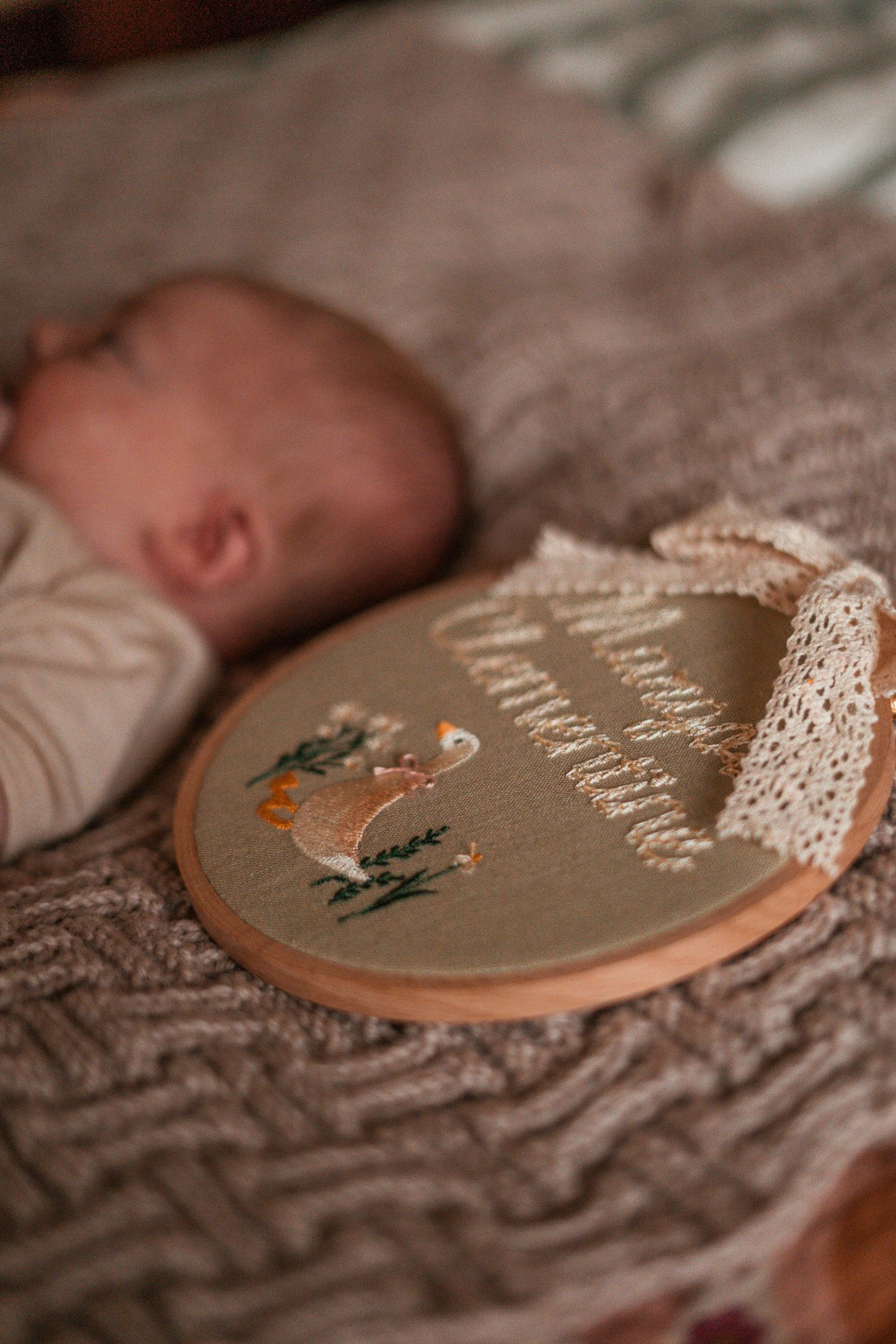 Close-up macro shots of an embroidery hoop with delicate lace trim and brown fabric in soft focus.