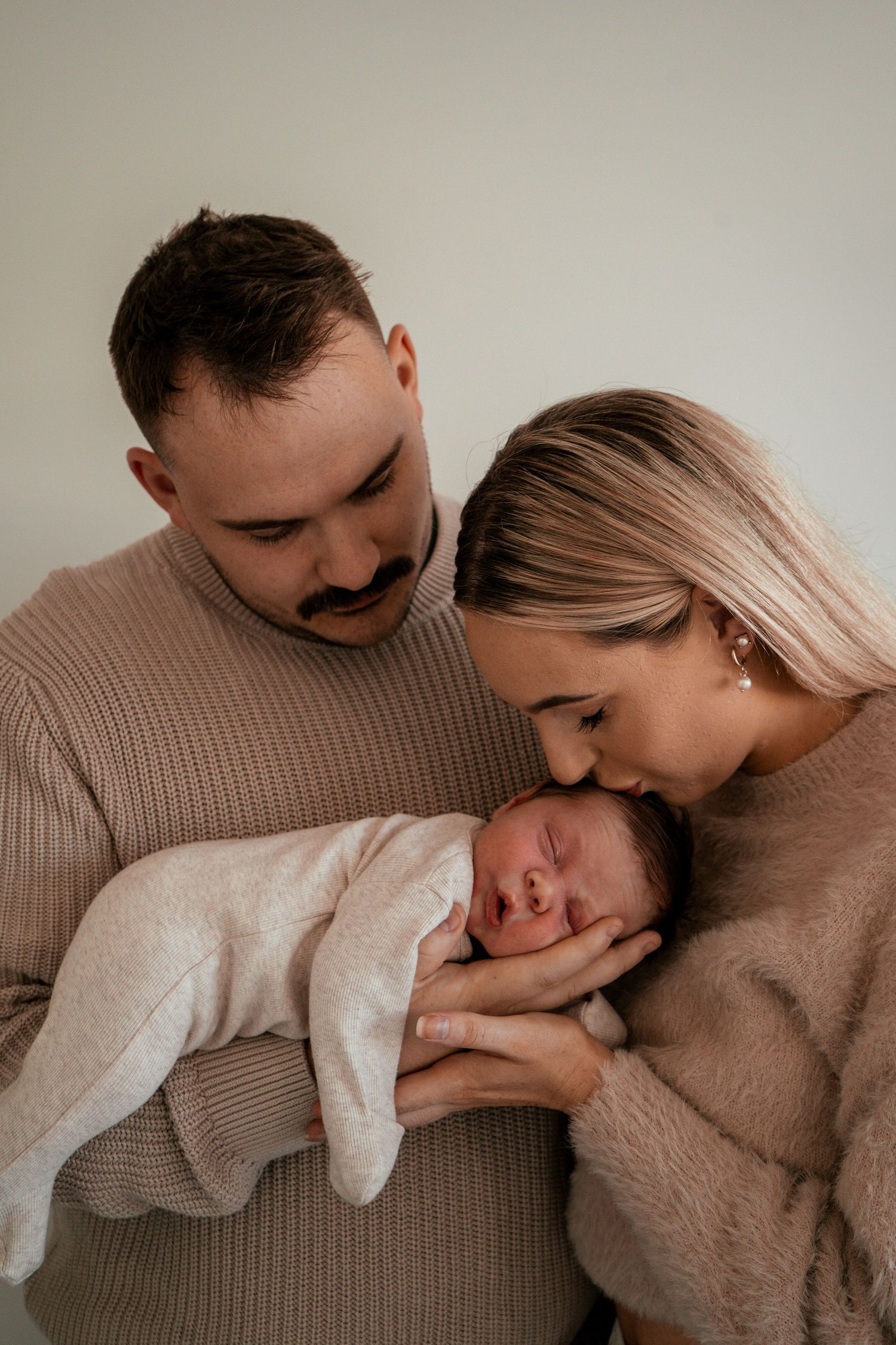 A tender series of intimate family moments captured in soft neutral tones showing affection and connection.