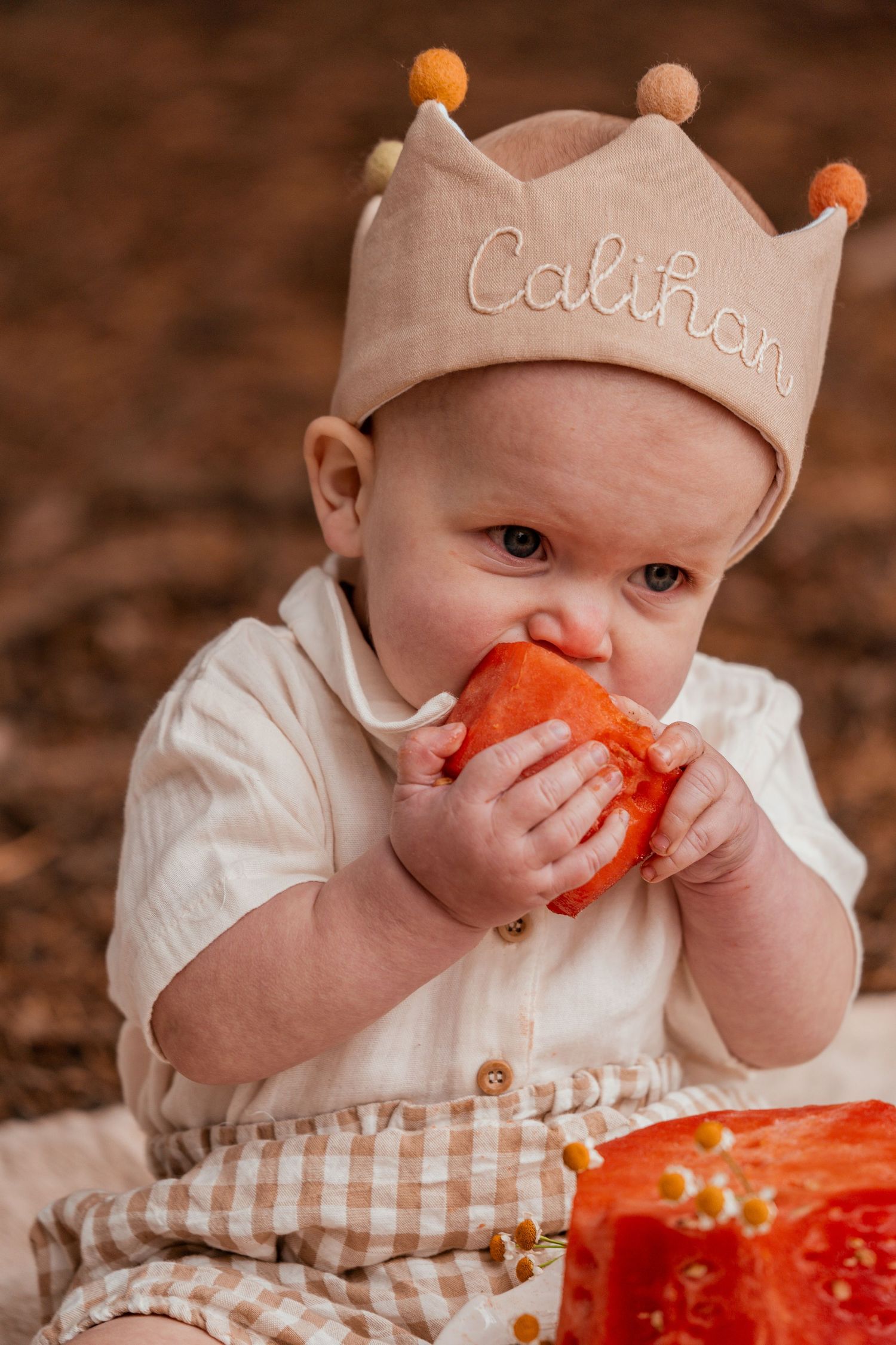 Baby in a striped outfit wearing a beige cap explores a bright orange object in a series of progressive photos.