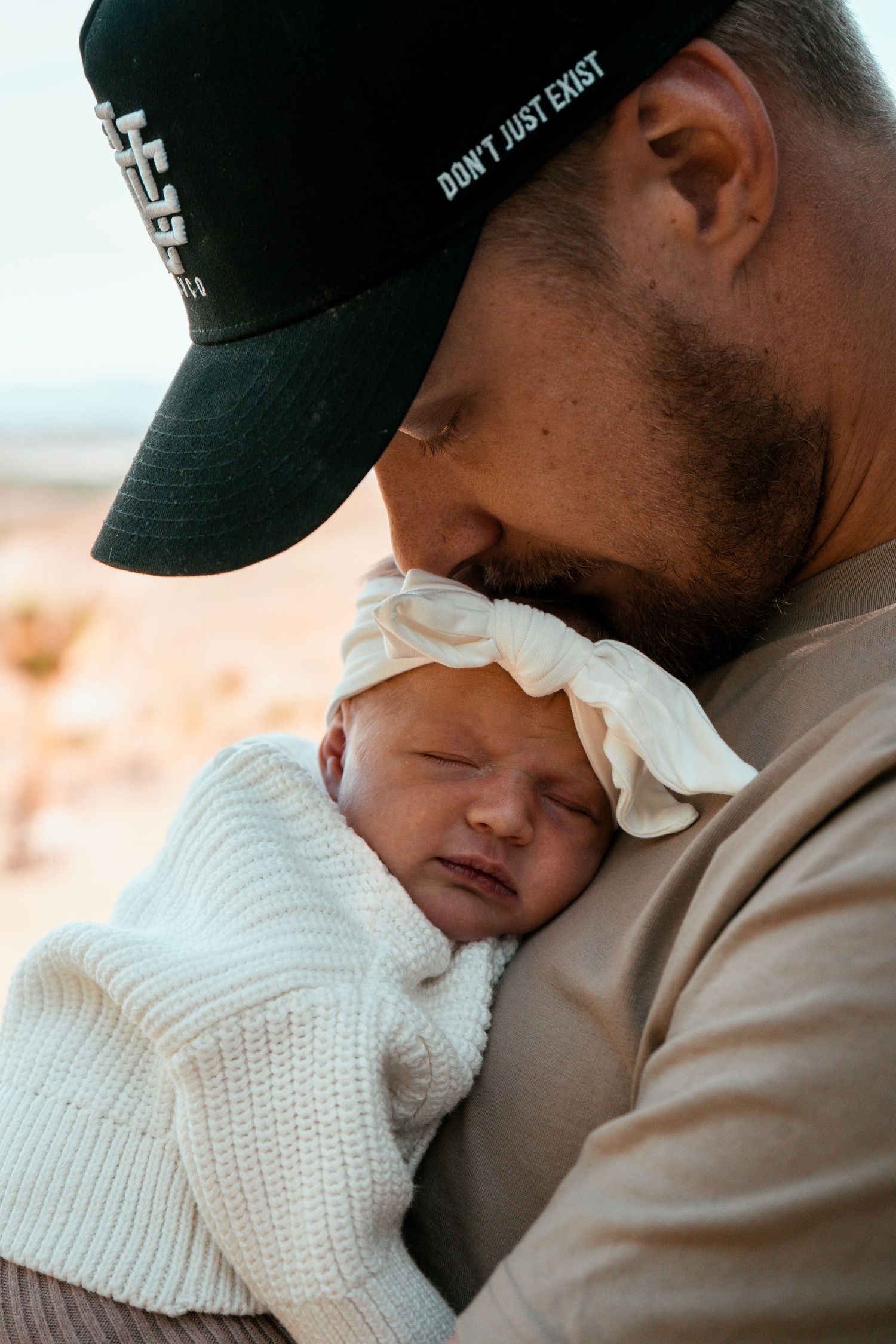 Tender moment with baby in white knit sweater nestled close.