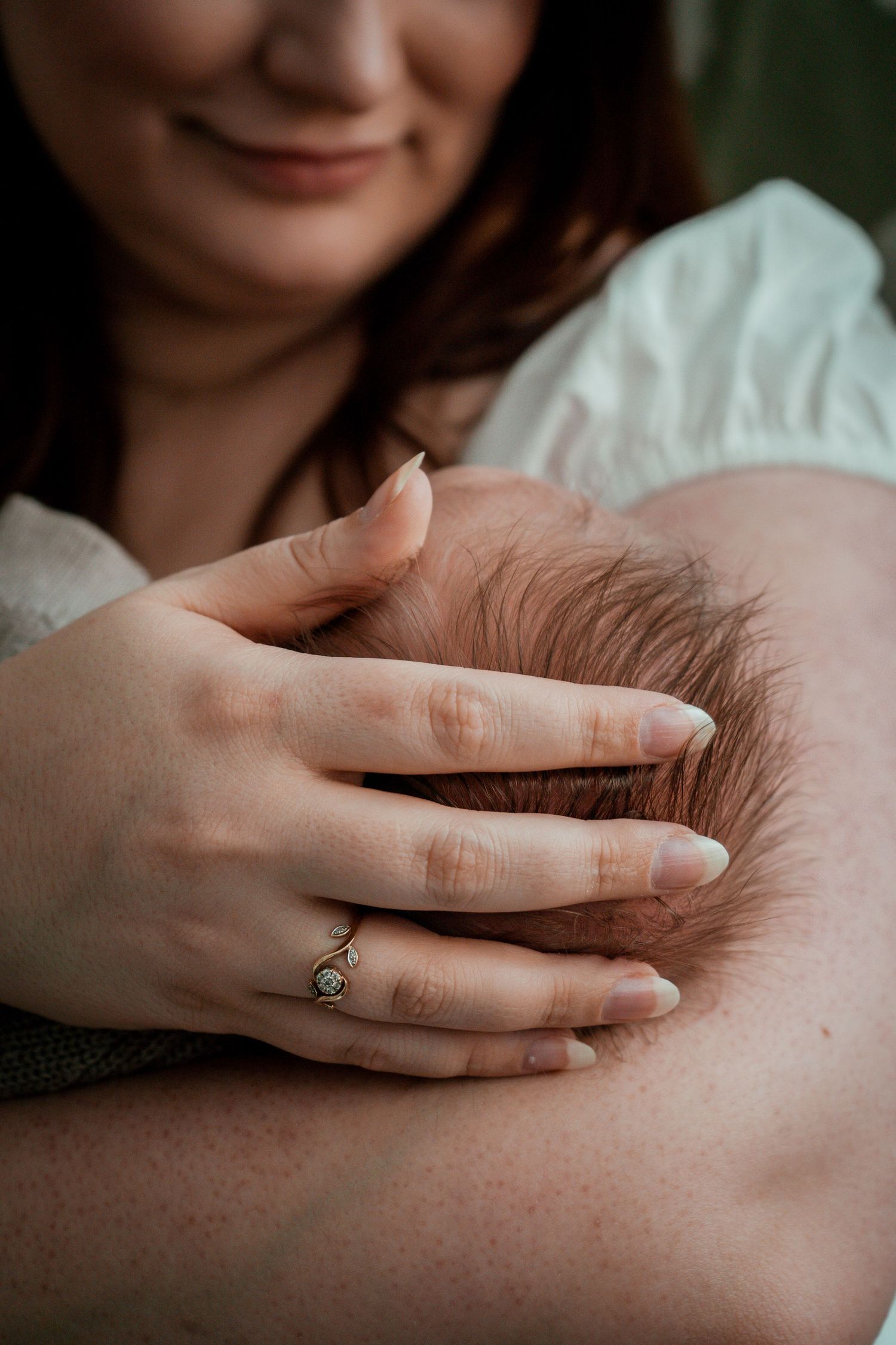A close-up series showing gentle hands with a delicate ring resting against skin in soft, natural lighting.